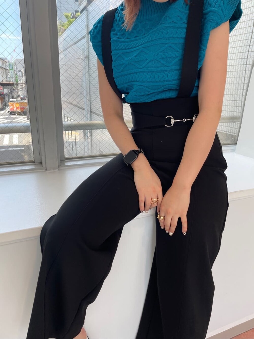 ブルー系のニット/セーター、ホワイト系のブーツ、ブラック系のスラックスを着用したレディースの夏コーディネートの3枚目の写真