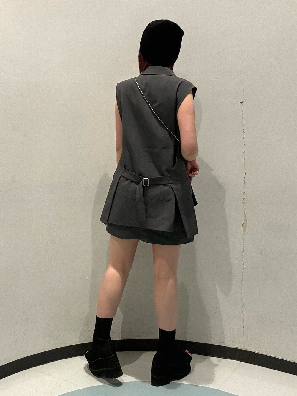 ブラック系のショルダーバッグ、グレー系のベスト、ブラック系のブーツを着用したレディースの夏コーディネートの3枚目の写真