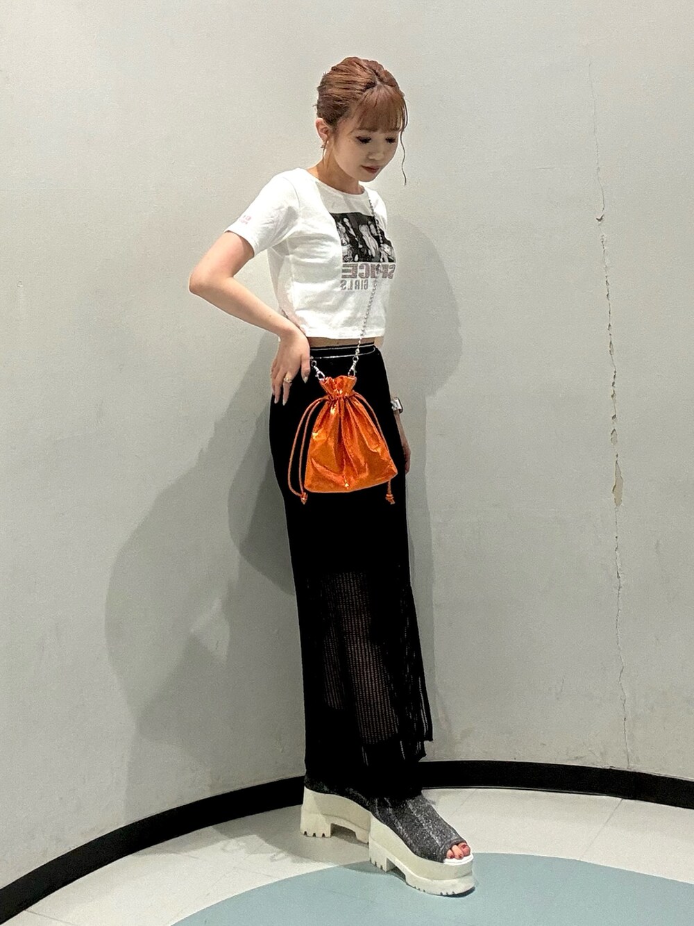 ホワイト系のTシャツ/カットソー、ブラック系のスカート、オレンジ系のショルダーバッグを着用したレディースの夏コーディネートの2枚目の写真