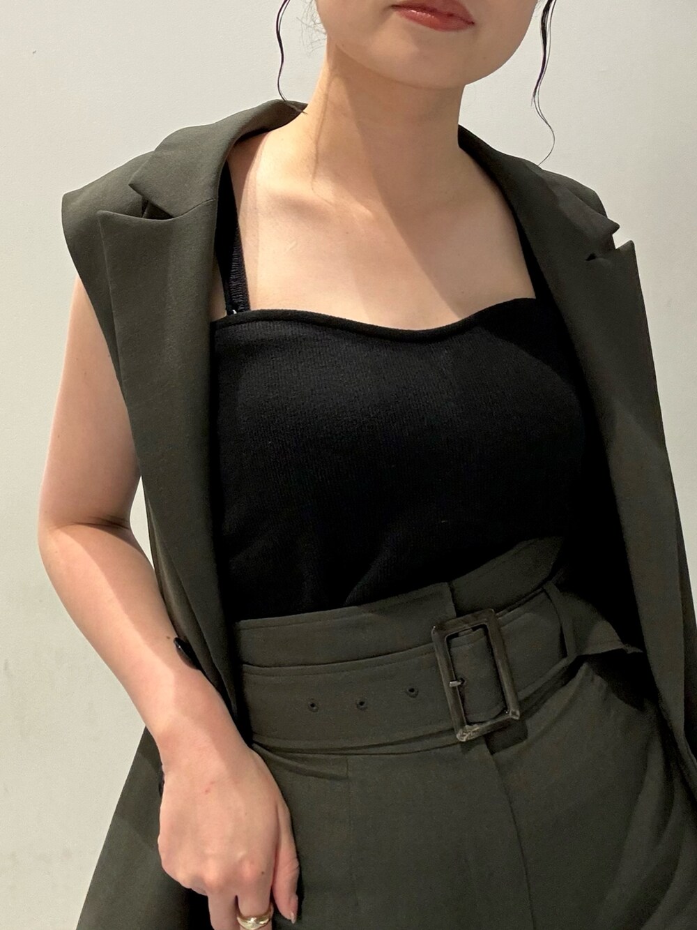 グレー系のベスト、グレー系のスカート、グレー系のショルダーバッグを着用したレディースの春コーディネートの6枚目の写真