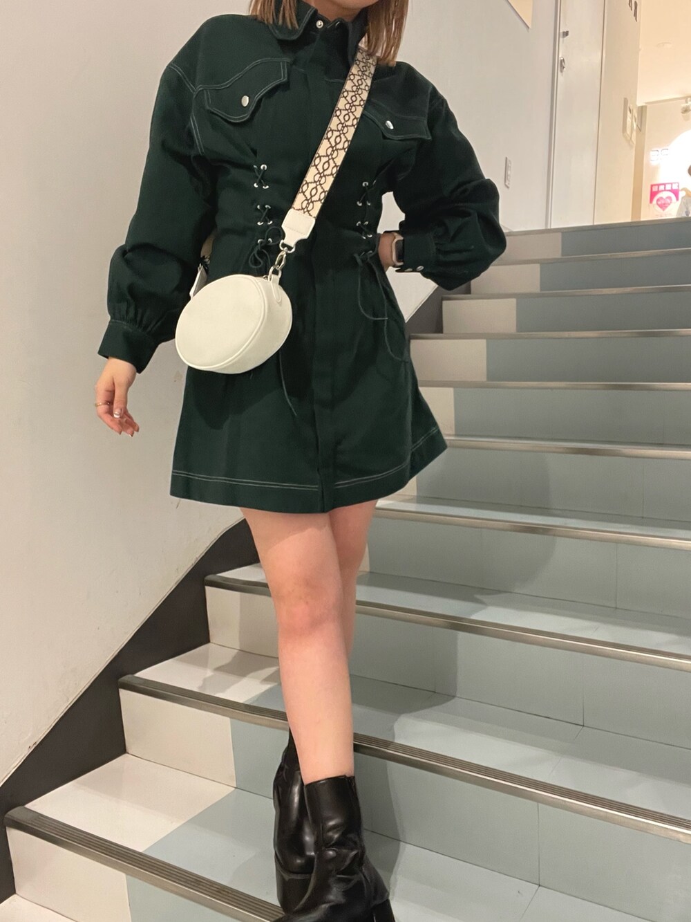 ホワイト系のショルダーバッグ、グリーン系のワンピースを着用したレディースの秋コーディネートの5枚目の写真