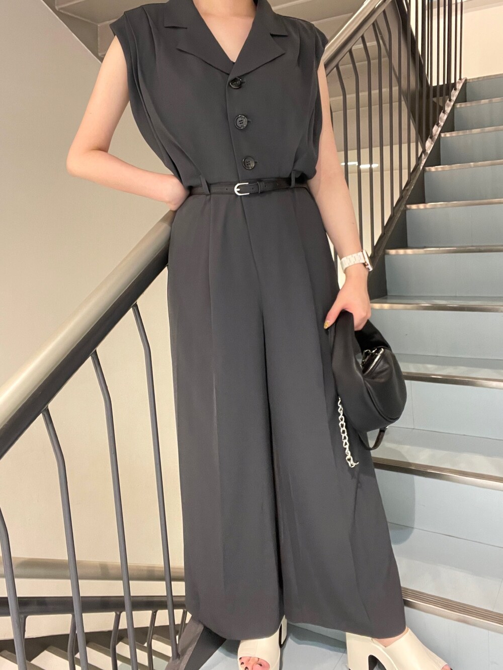 ブラック系のハンドバッグ、ホワイト系のつなぎ/オールインワン、ホワイト系のサンダルを着用したレディースの春コーディネートの4枚目の写真