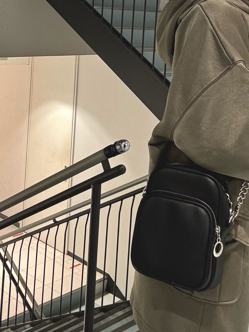 ブラック系のショルダーバッグ、ブラウン系のスカート、ブラウン系のTシャツ/カットソーを着用したレディースの冬コーディネートの6枚目の写真