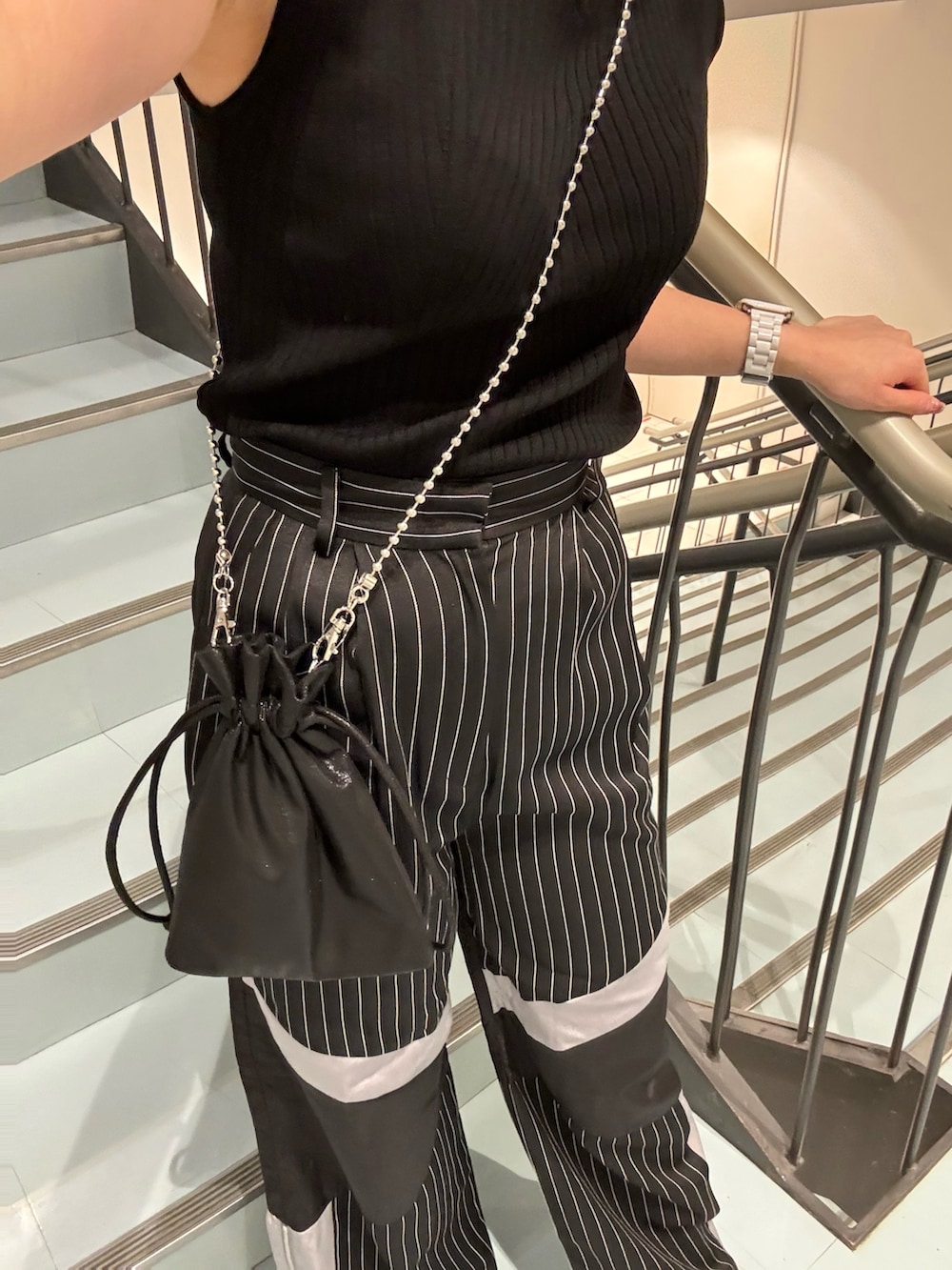 ブラック系のその他パンツ、ブラック系のショルダーバッグ、ブラック系のニット/セーターを着用したレディースの夏コーディネートの6枚目の写真