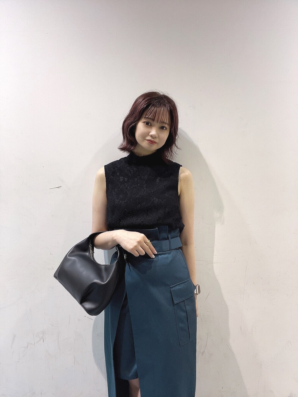 ブラック系のハンドバッグ、ブルー系のスカート、ブラック系のシャツ/ブラウスを着用したレディースの夏コーディネートの2枚目の写真