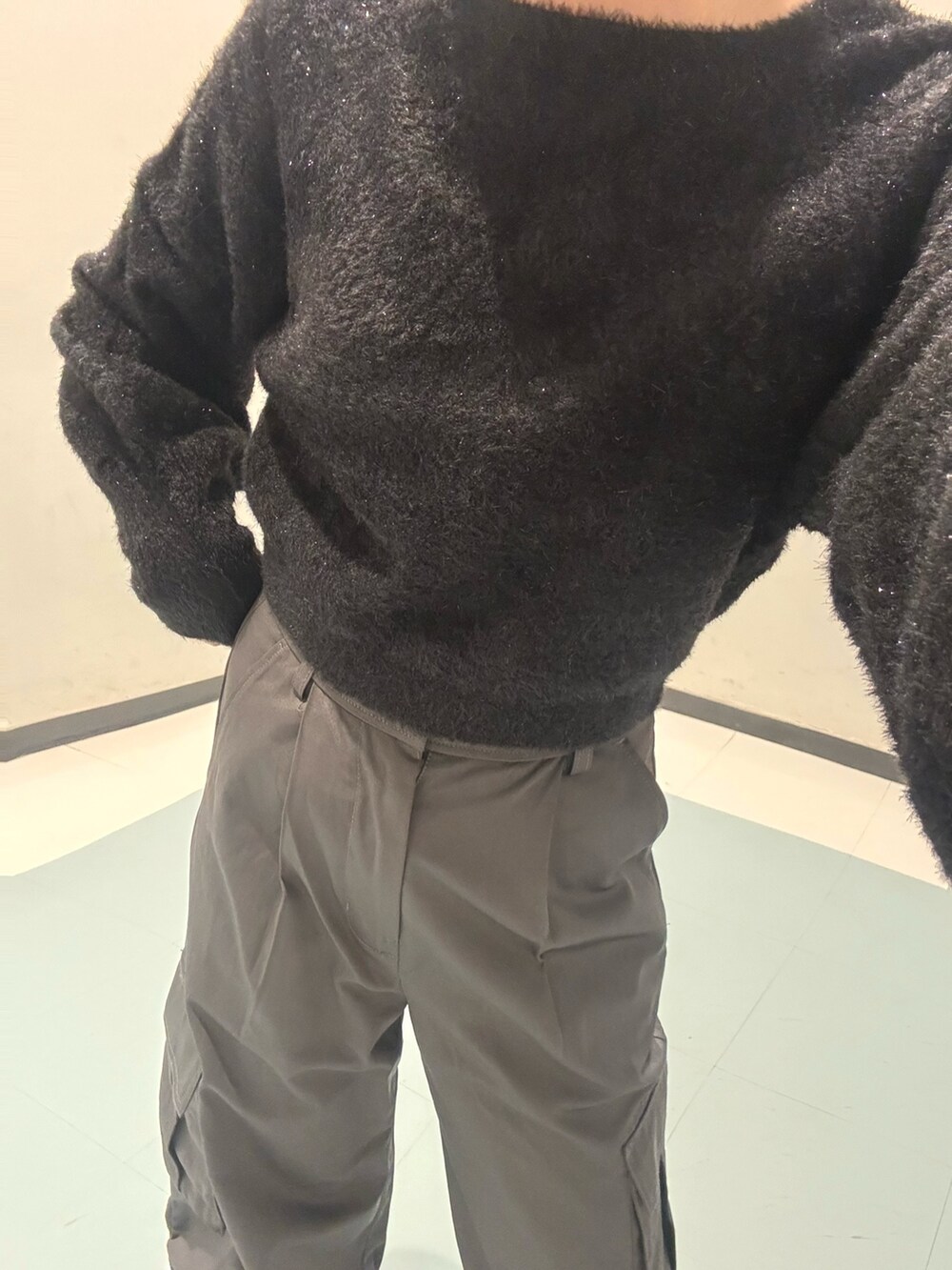 ホワイト系のブーツ、ブラック系のニット/セーター、グレー系のカーゴパンツを着用したレディースの冬コーディネートの6枚目の写真