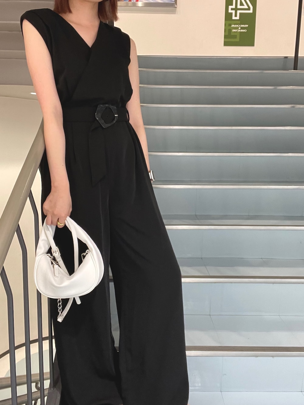 ホワイト系のハンドバッグ、ブラック系のサロペット/オーバーオールを着用したレディースの夏コーディネートの7枚目の写真
