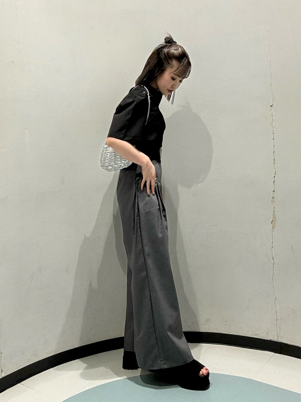 シルバー系のショルダーバッグ、ブラック系のシャツ/ブラウス、グレー系のその他パンツを着用したレディースの春コーディネートの2枚目の写真