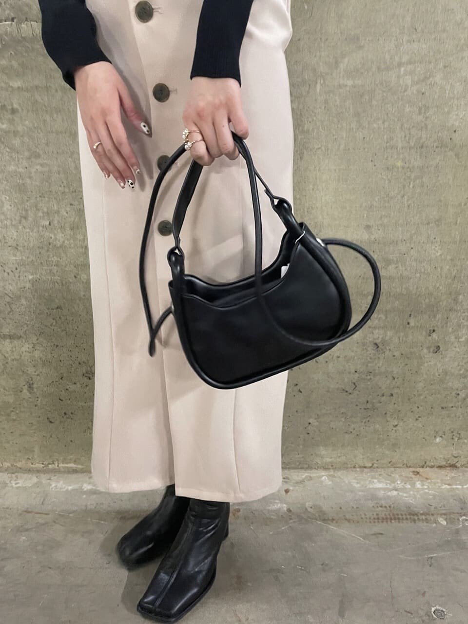 ブラック系のニット/セーター、ホワイト系のワンピース、ベージュ系のトレンチコートを着用したレディースの秋コーディネートの5枚目の写真