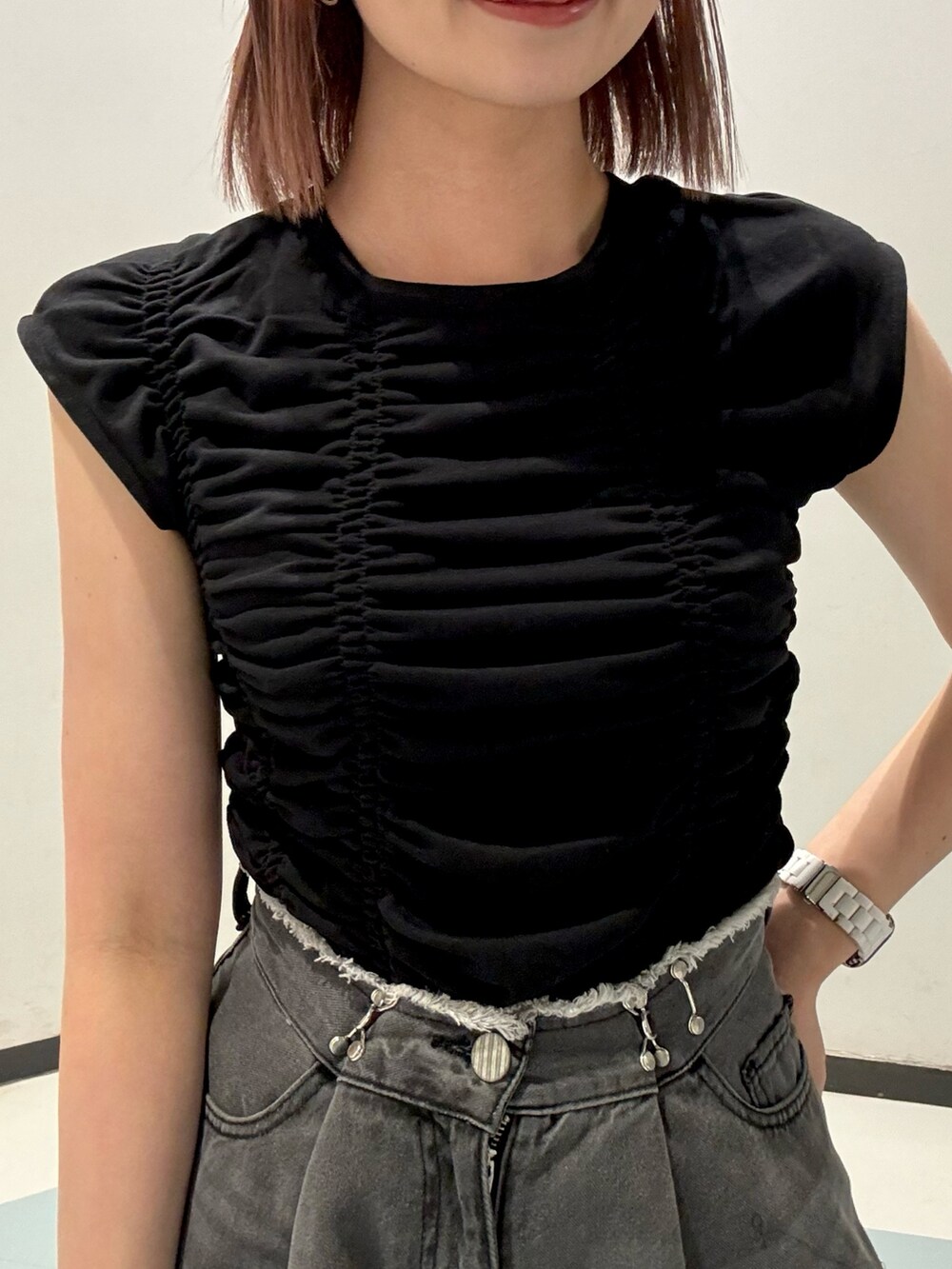 オレンジ系のショルダーバッグ、ブラック系のTシャツ/カットソー、ブラック系のデニムパンツを着用したレディースの夏コーディネートの5枚目の写真