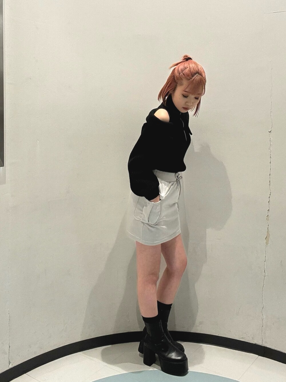 グリーン系のハンドバッグ、グレー系のスカート、ブラック系のニット/セーターを着用したレディースの冬コーディネートの5枚目の写真