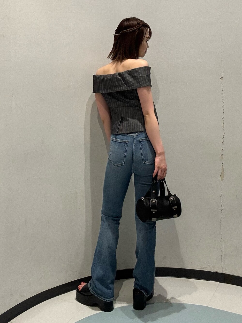 ブラック系のハンドバッグ、グレー系のシャツ/ブラウス、ブラック系のサンダルを着用したレディースの春コーディネートの3枚目の写真