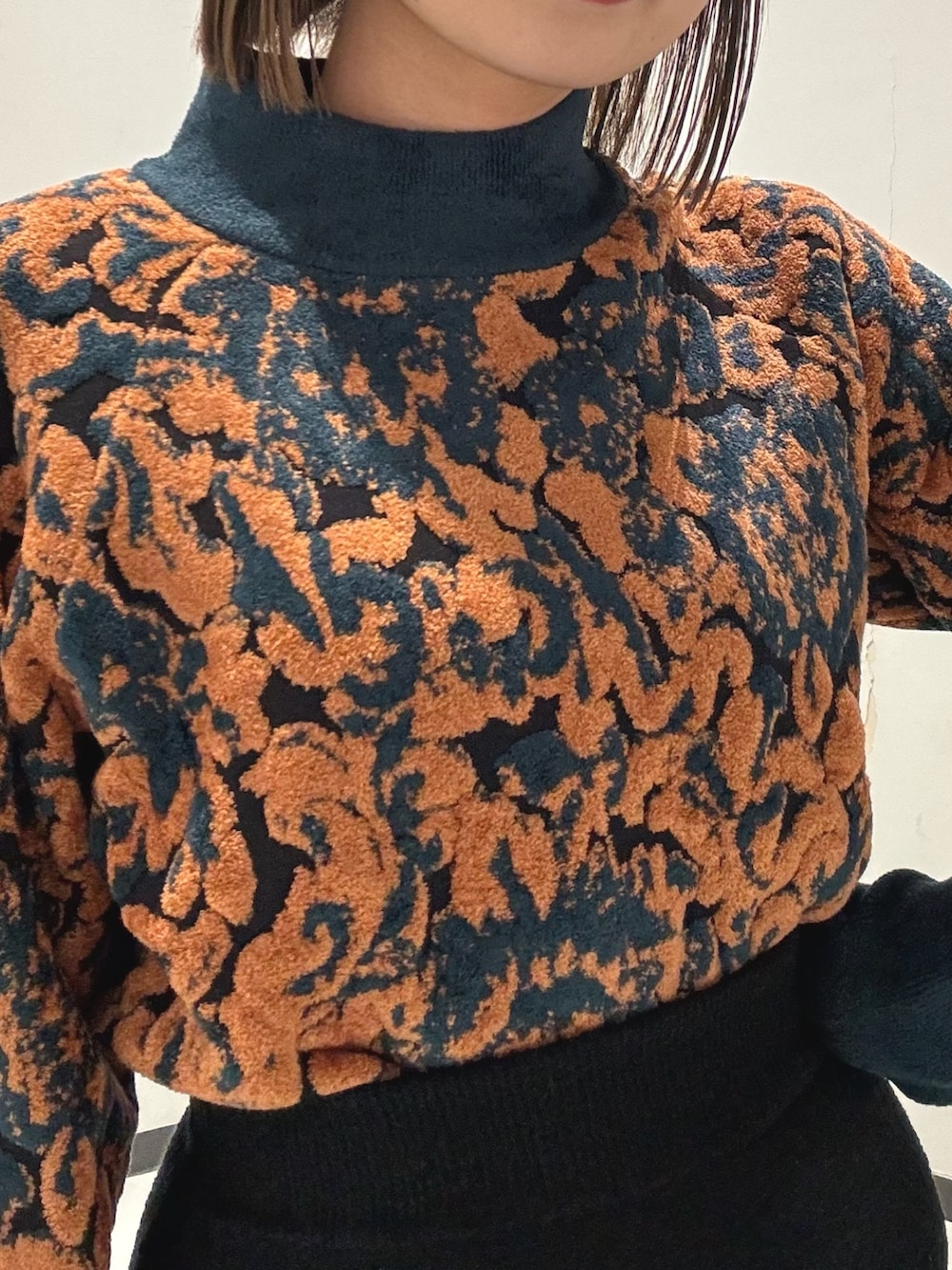 ブラック系のスカート、グリーン系のニット/セーター、ブラック系のハンドバッグを着用したレディースの冬コーディネートの6枚目の写真