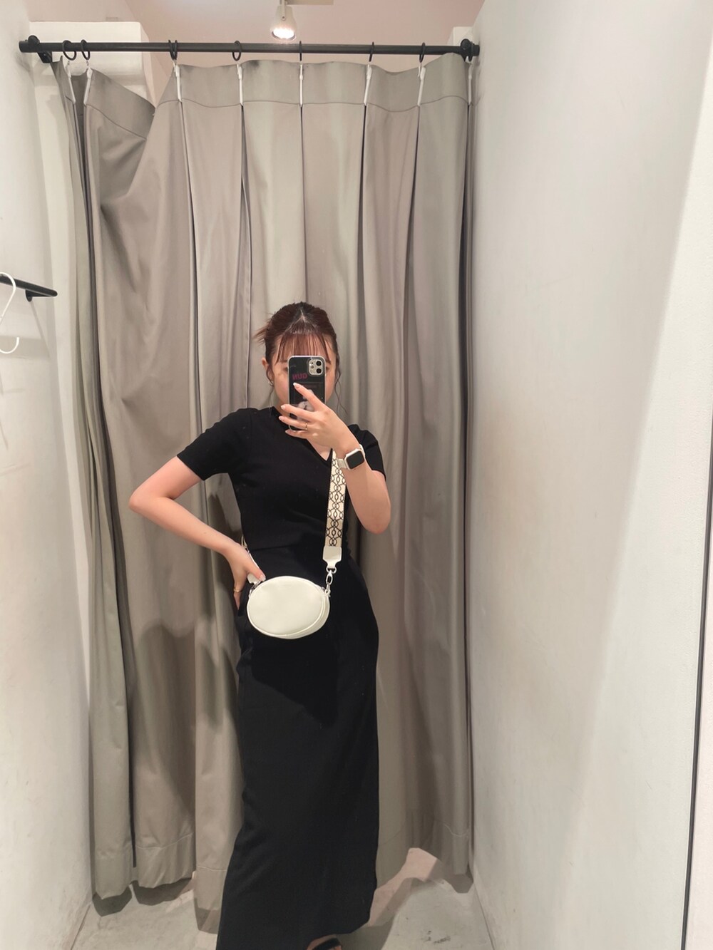 ブラック系のワンピース、ホワイト系のショルダーバッグを着用したレディースの夏コーディネートの3枚目の写真