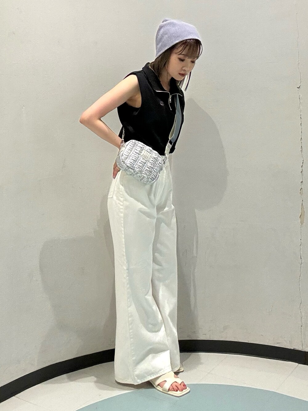 ブラック系のTシャツ/カットソー、シルバー系のショルダーバッグ、ホワイト系のデニムパンツを着用したレディースの春コーディネートの2枚目の写真