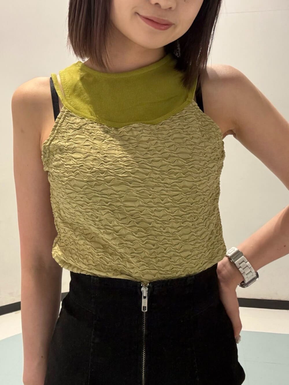 ブラック系のサンダル、グリーン系のタンクトップ、ブラック系のハンドバッグを着用したレディースの夏コーディネートの4枚目の写真