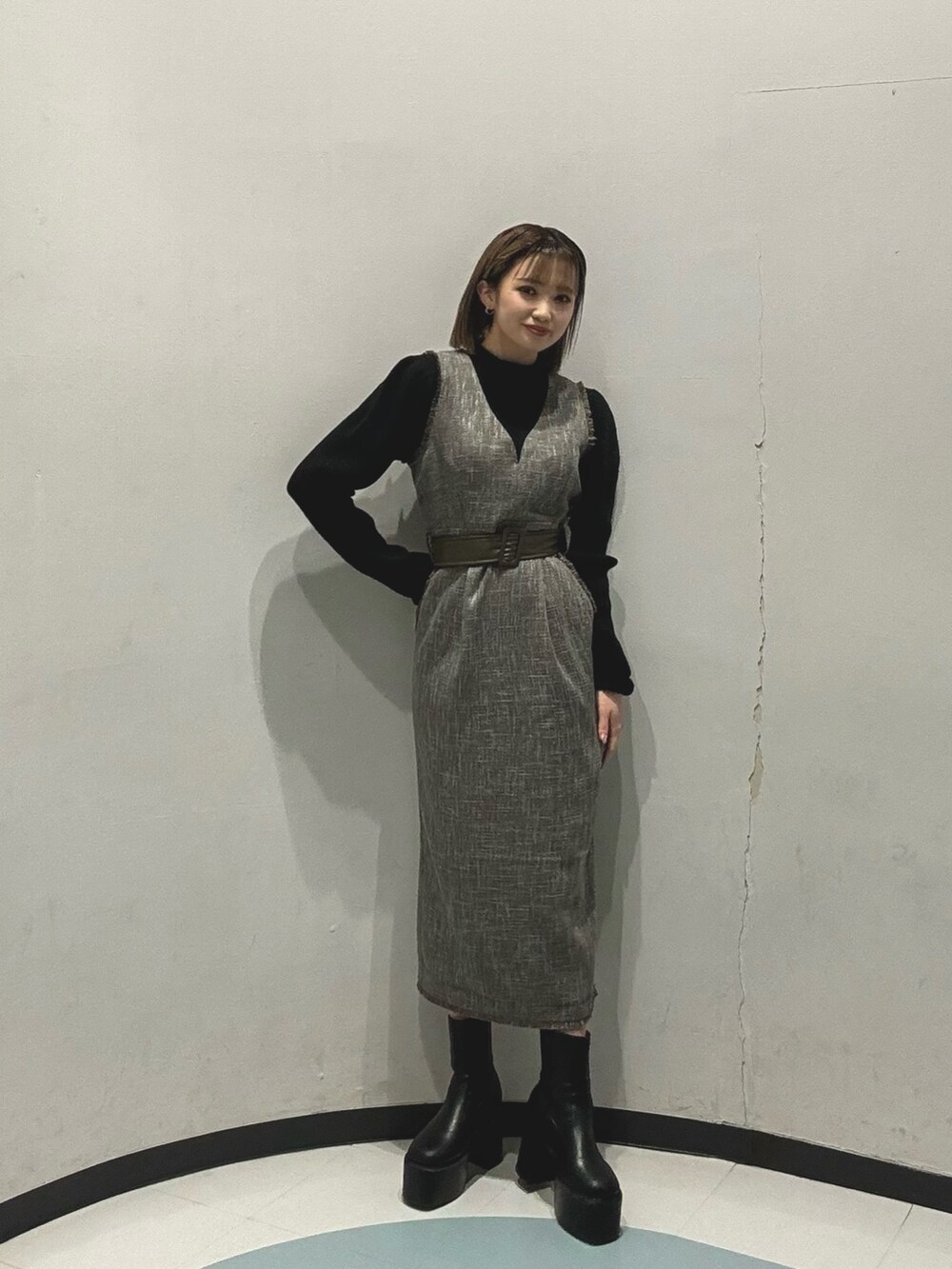 グレー系のダウンジャケット/コート、ブラック系のニット/セーター、グレー系のワンピースを着用したレディースの冬コーディネートの3枚目の写真