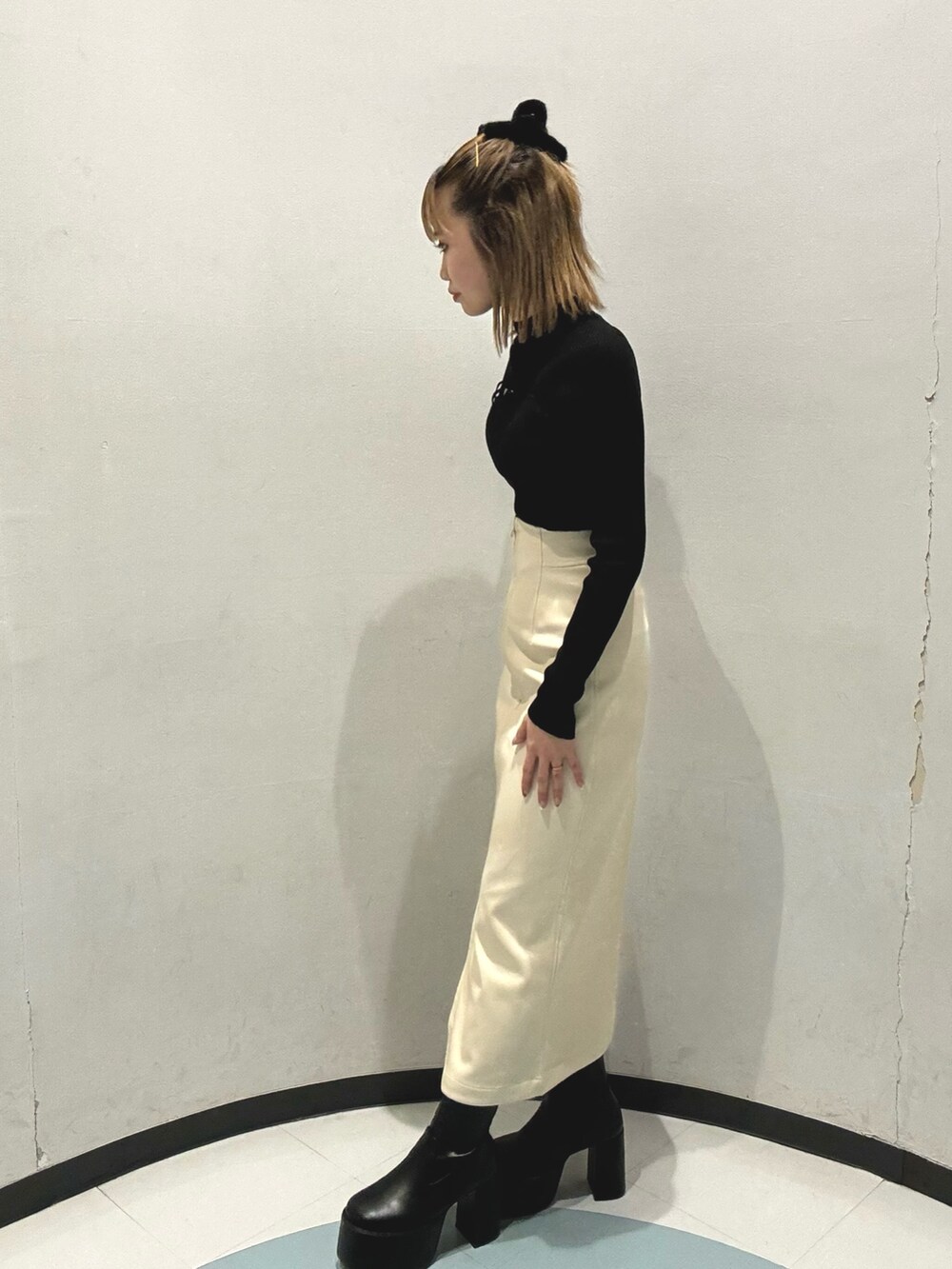 グレー系のダウンジャケット/コート、ホワイト系のニット/セーター、ブラック系のスカートを着用したレディースの秋コーディネートの5枚目の写真