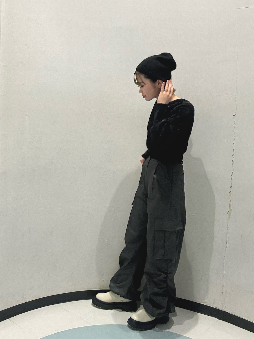 ホワイト系のブーツ、ブラック系のニット/セーター、グレー系のカーゴパンツを着用したレディースの冬コーディネートの3枚目の写真