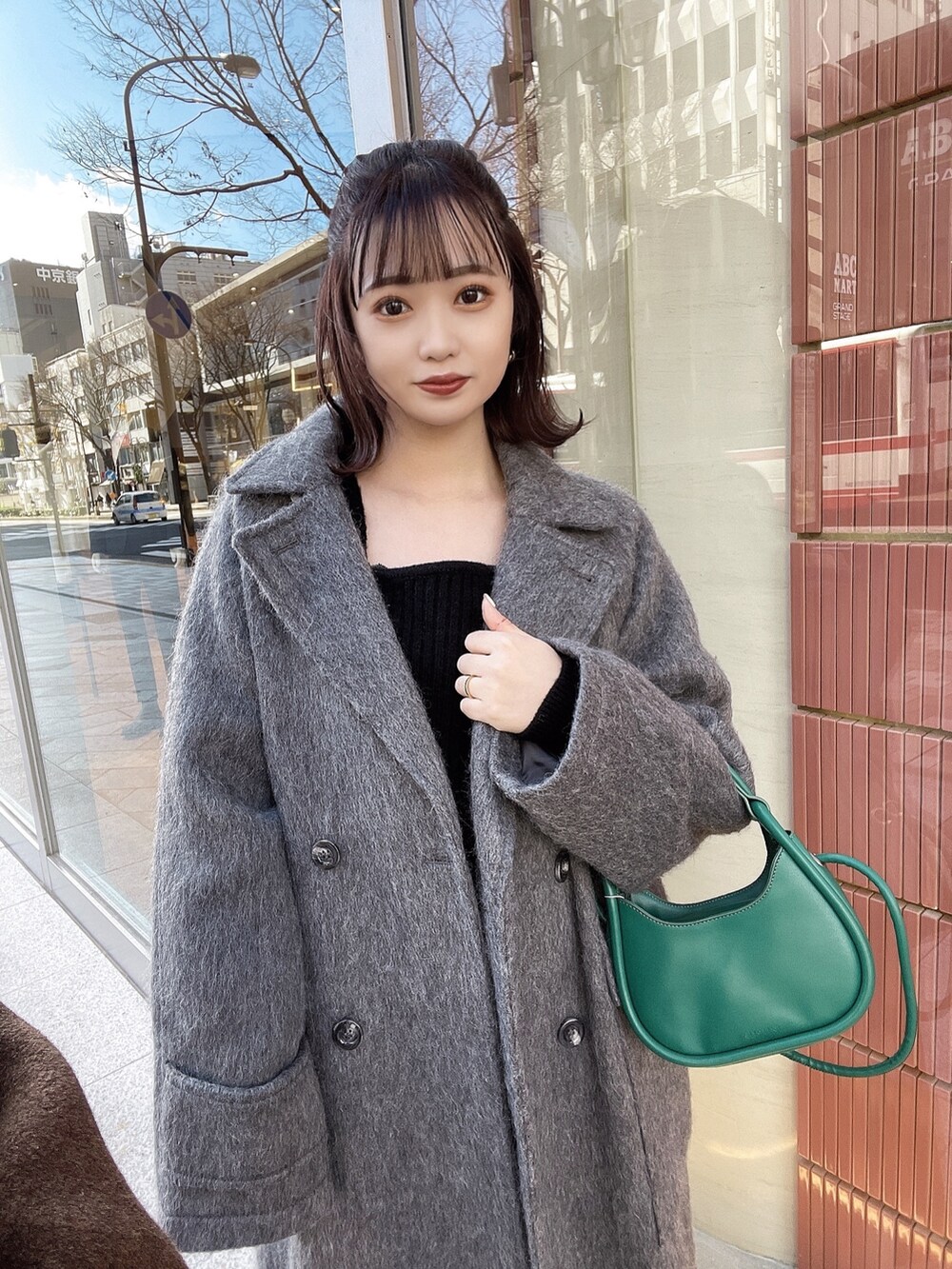 グレー系のチェスターコート、ブラック系のワンピース、ブラック系のローファーを着用したレディースの冬コーディネートの3枚目の写真