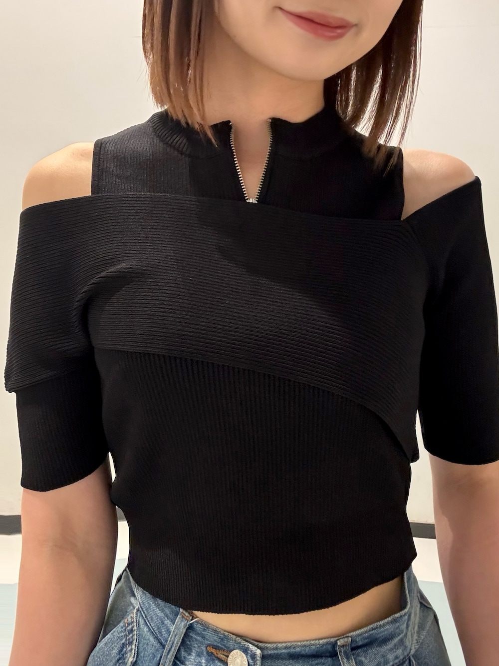 ブラック系のニット/セーター、ブラック系のハンドバッグ、ブラック系のサンダルを着用したレディースの夏コーディネートの4枚目の写真