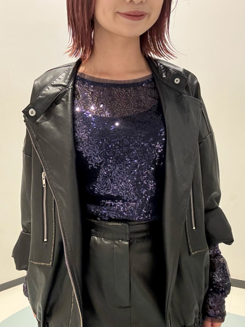 ブルー系のTシャツ/カットソー、ブラック系のライダースジャケット、ブラック系のスカートを着用したレディースの秋コーディネートの4枚目の写真