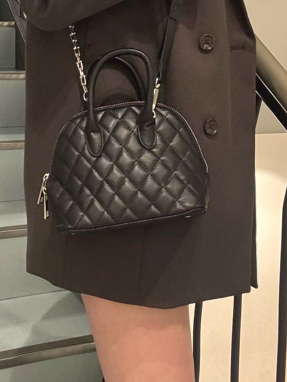 グレー系のテーラードジャケット、ブラック系のハンドバッグ、グレー系のシャツ/ブラウスを着用したレディースの冬コーディネートの6枚目の写真