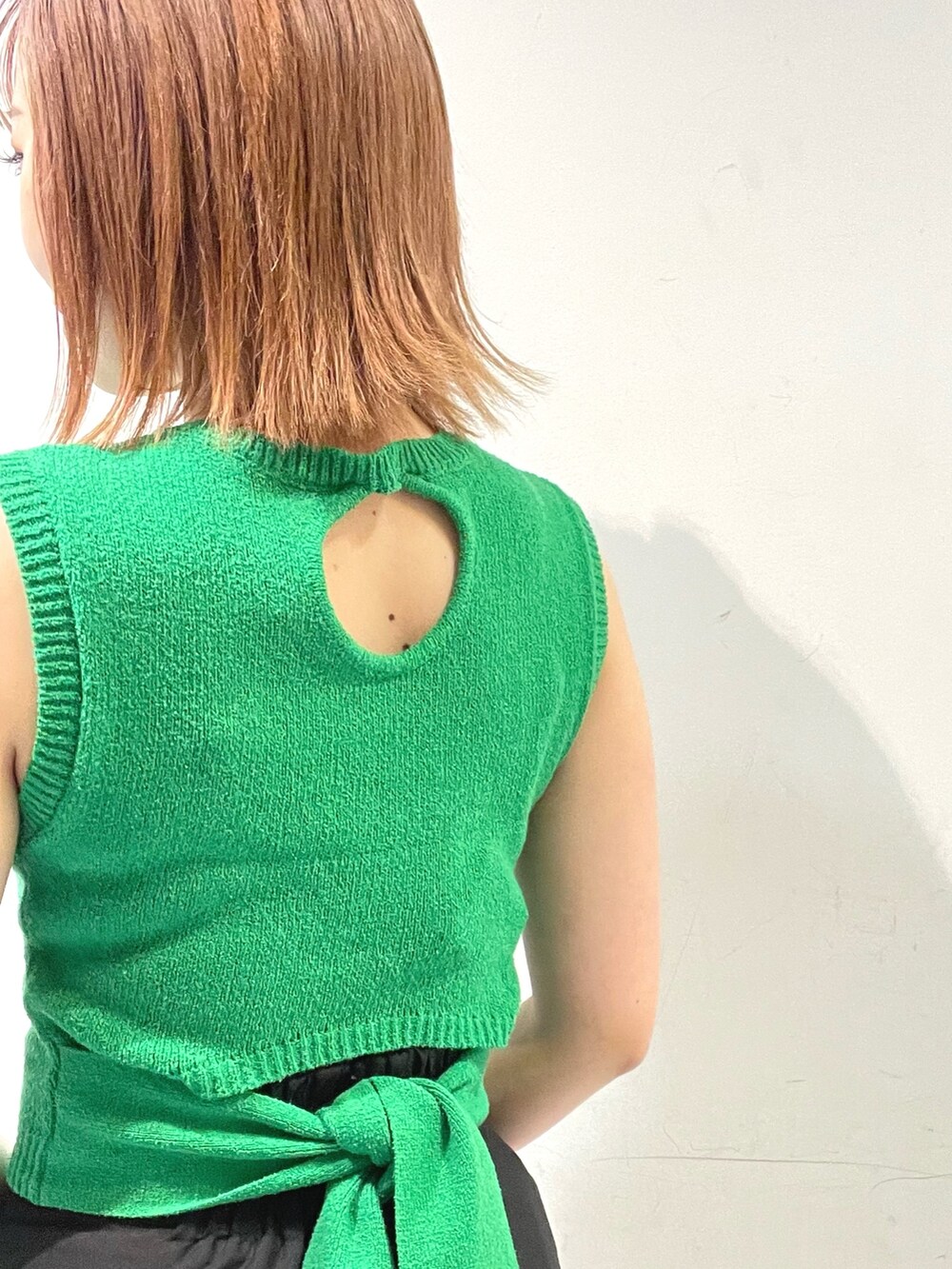 ブラック系のスカート、グリーン系のタンクトップ、ブラック系のサンダルを着用したレディースの春コーディネートの6枚目の写真