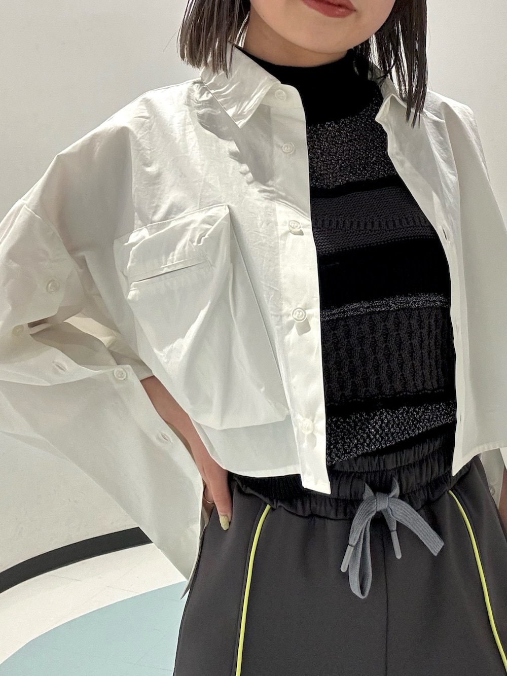 ブラック系のハンドバッグ、ブラック系のニット/セーター、グレー系のその他パンツを着用したレディースの春コーディネートの4枚目の写真
