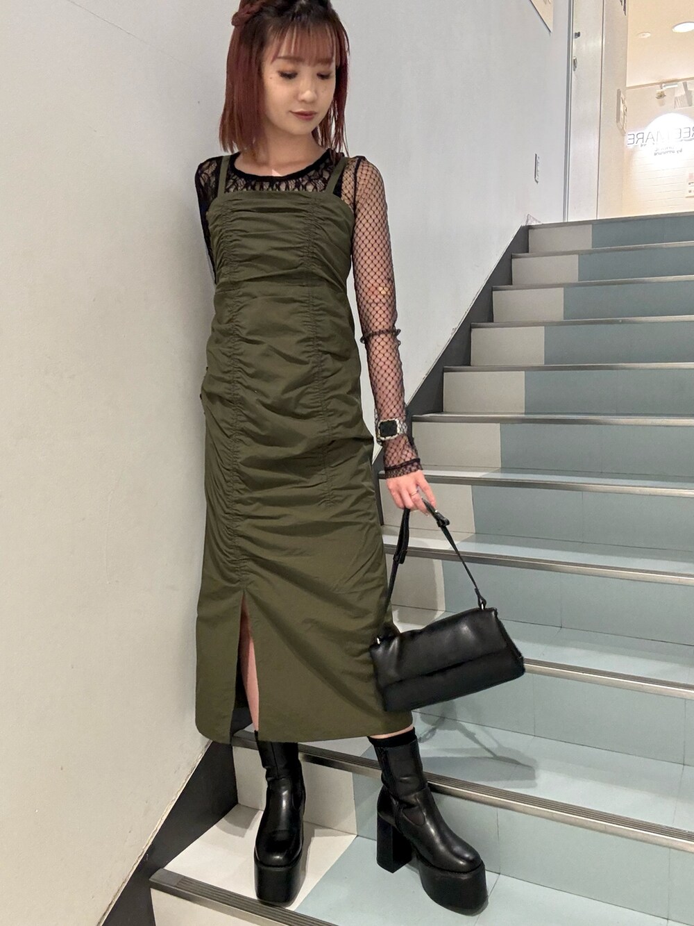 ブラック系のハンドバッグ、ブラック系のTシャツ/カットソー、ブラック系のブーツを着用したレディースの秋コーディネートの4枚目の写真