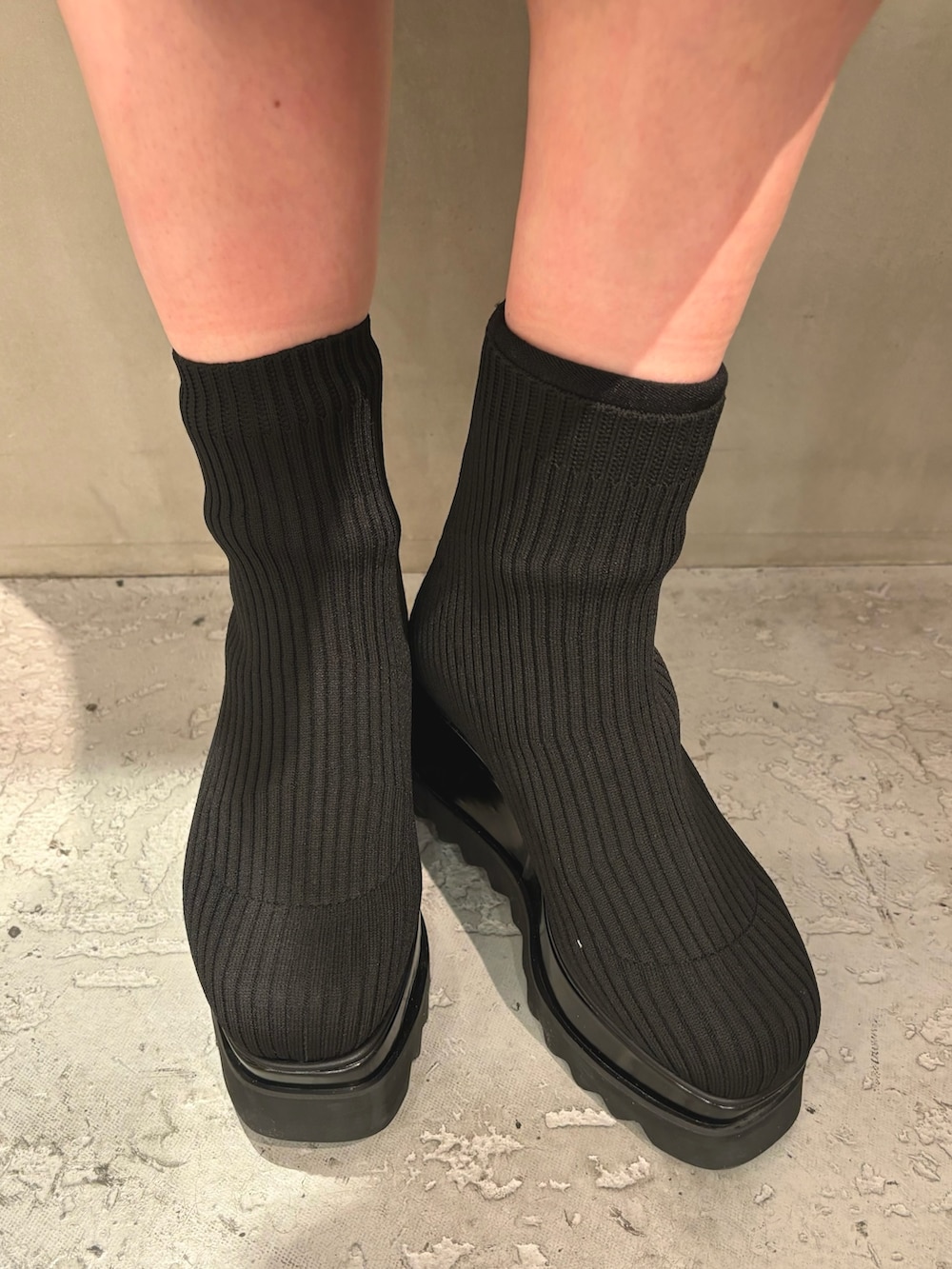 ブルー系のワンピース、ブラック系のハンドバッグ、ブラック系のブーツを着用したレディースの冬コーディネートの7枚目の写真