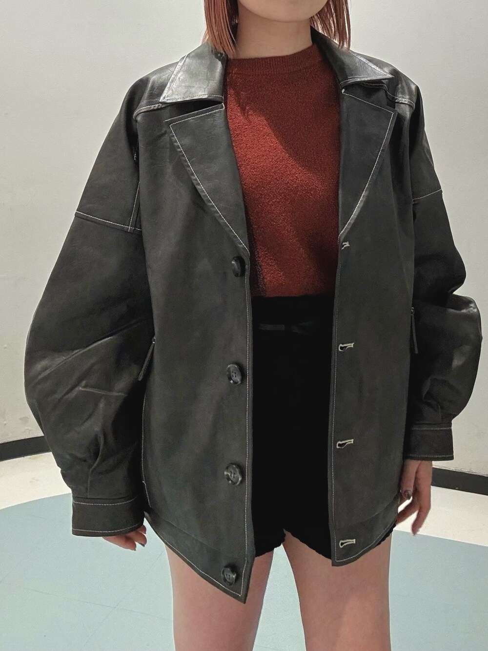 ブラック系のその他パンツ、オレンジ系のニット/セーター、グレー系のブルゾンを着用したレディースの冬コーディネートの6枚目の写真