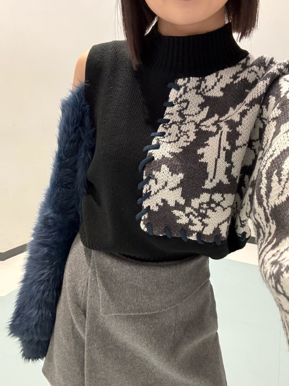 グレー系のスカート、ブラック系のブルゾン、ブラック系のニット/セーターを着用したレディースの冬コーディネートの4枚目の写真