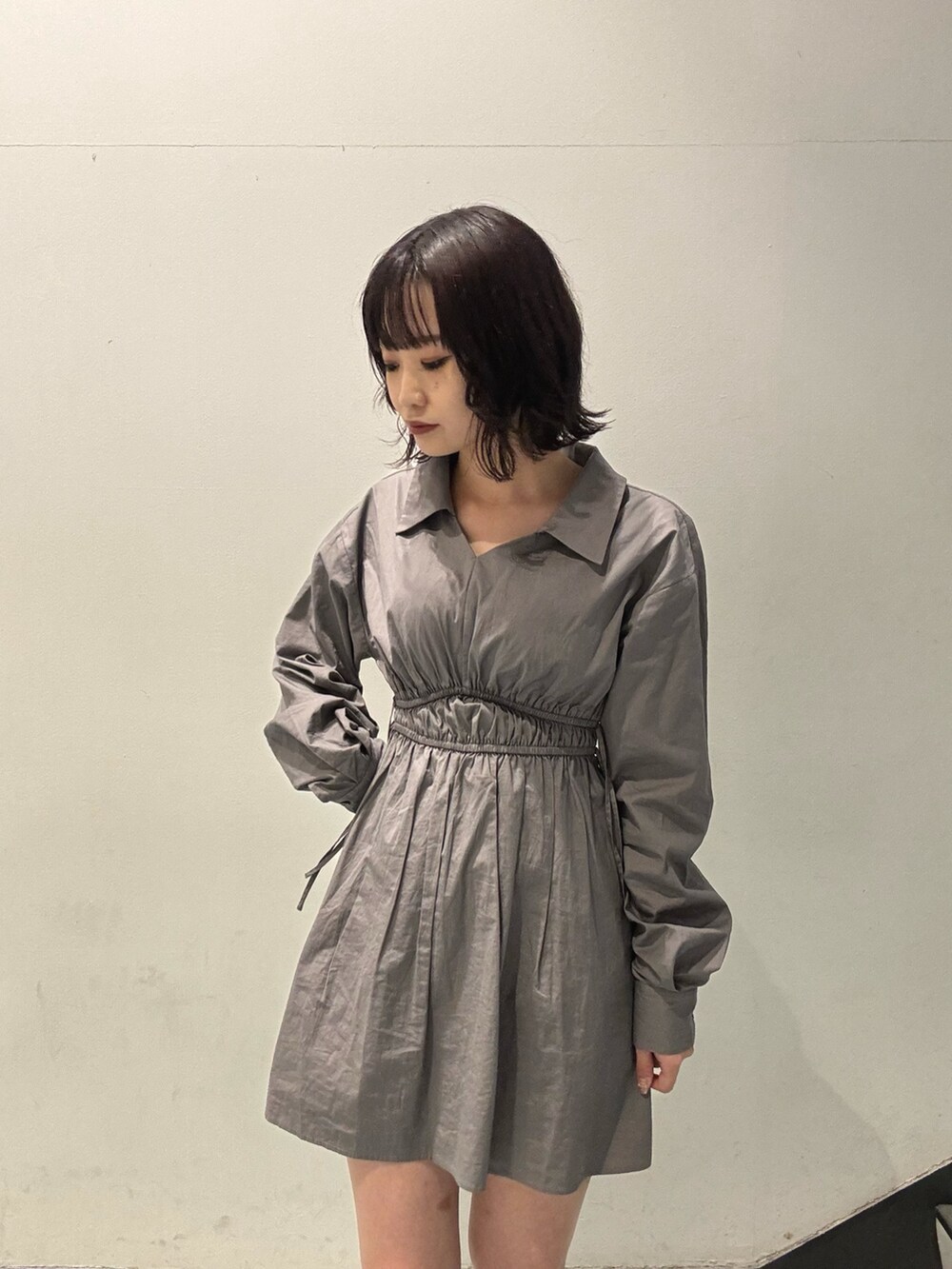 ブラック系のブーツ、グレー系のワンピースを着用したレディースの秋コーディネートの6枚目の写真