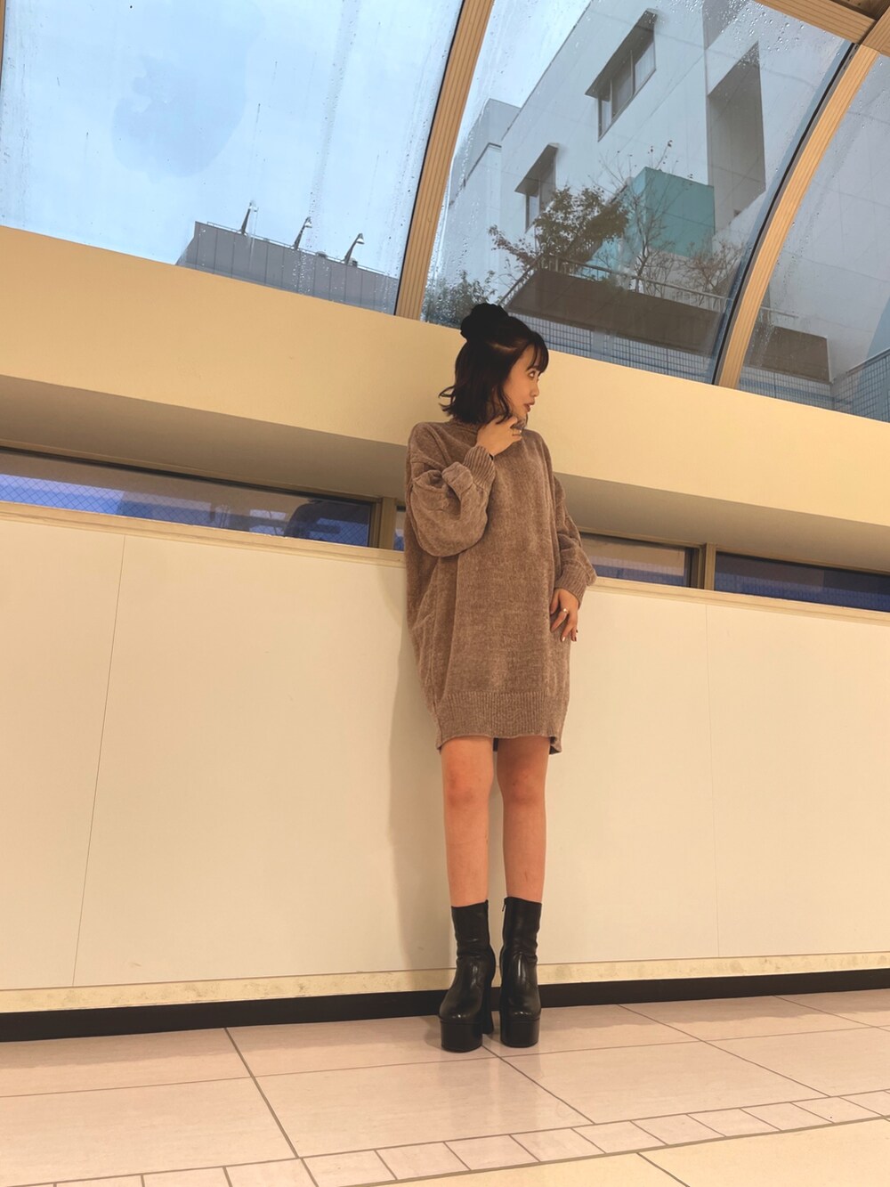 グリーン系のステンカラーコート、ブラウン系のワンピースを着用したレディースの秋コーディネートの2枚目の写真