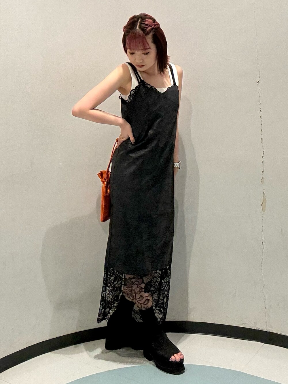 ブラック系のワンピース、ホワイト系のニット/セーター、ブラック系のブーツを着用したレディースの夏コーディネートの2枚目の写真