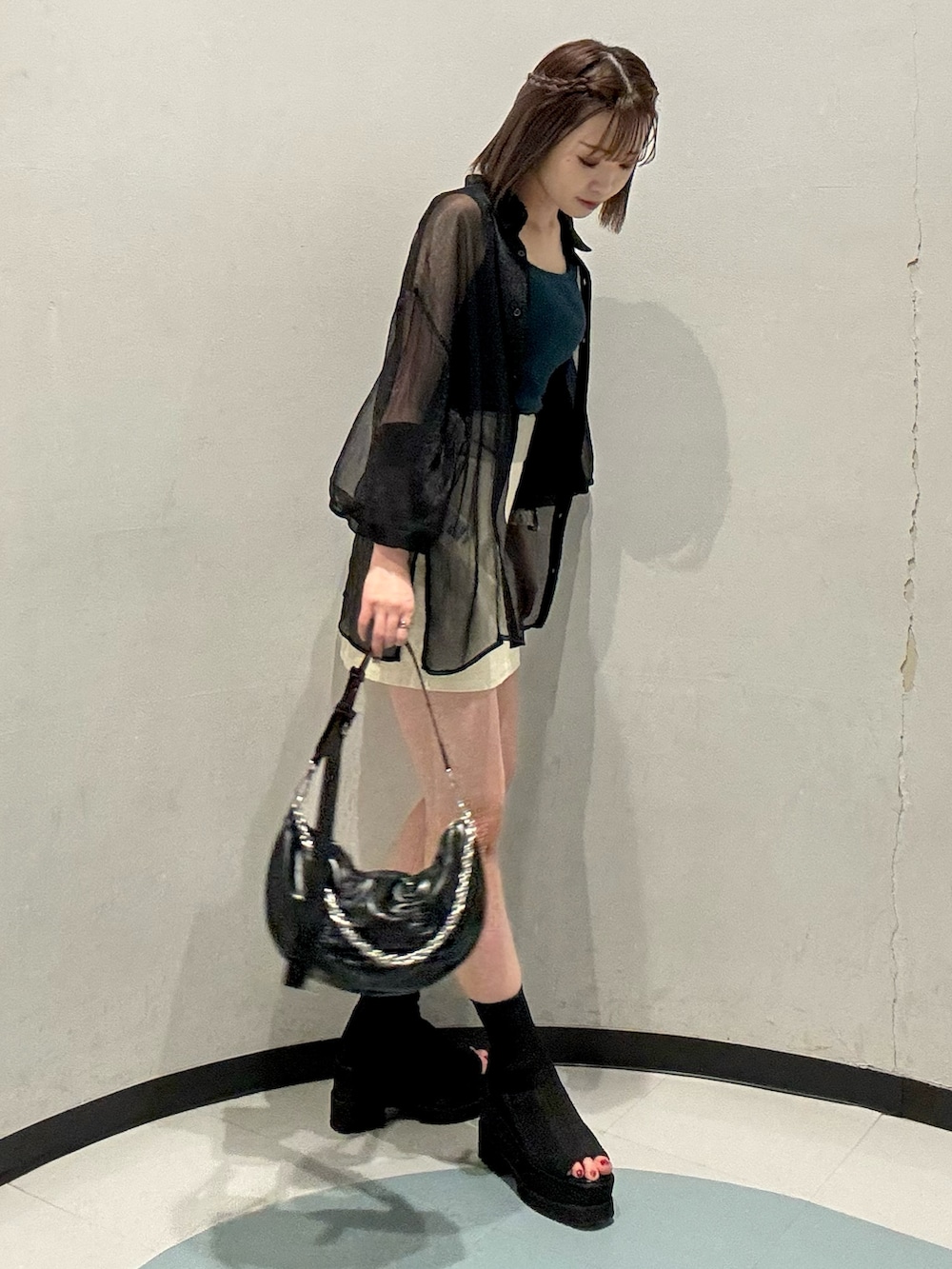 ブラック系のシャツ/ブラウス、グリーン系のニット/セーター、ブラック系のサンダルを着用したレディースの春コーディネートの2枚目の写真