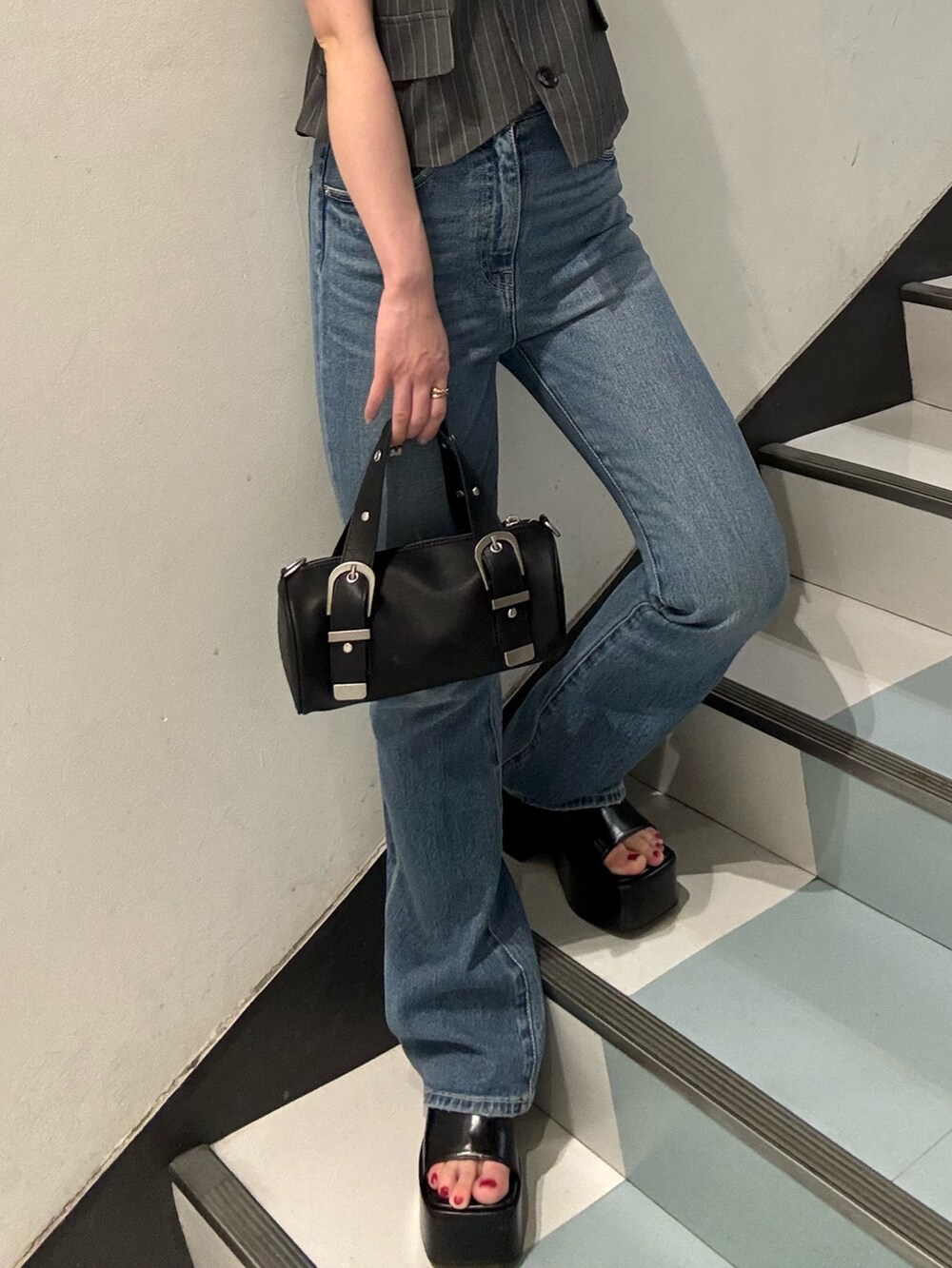 ブラック系のハンドバッグ、グレー系のシャツ/ブラウス、ブラック系のサンダルを着用したレディースの春コーディネートの6枚目の写真