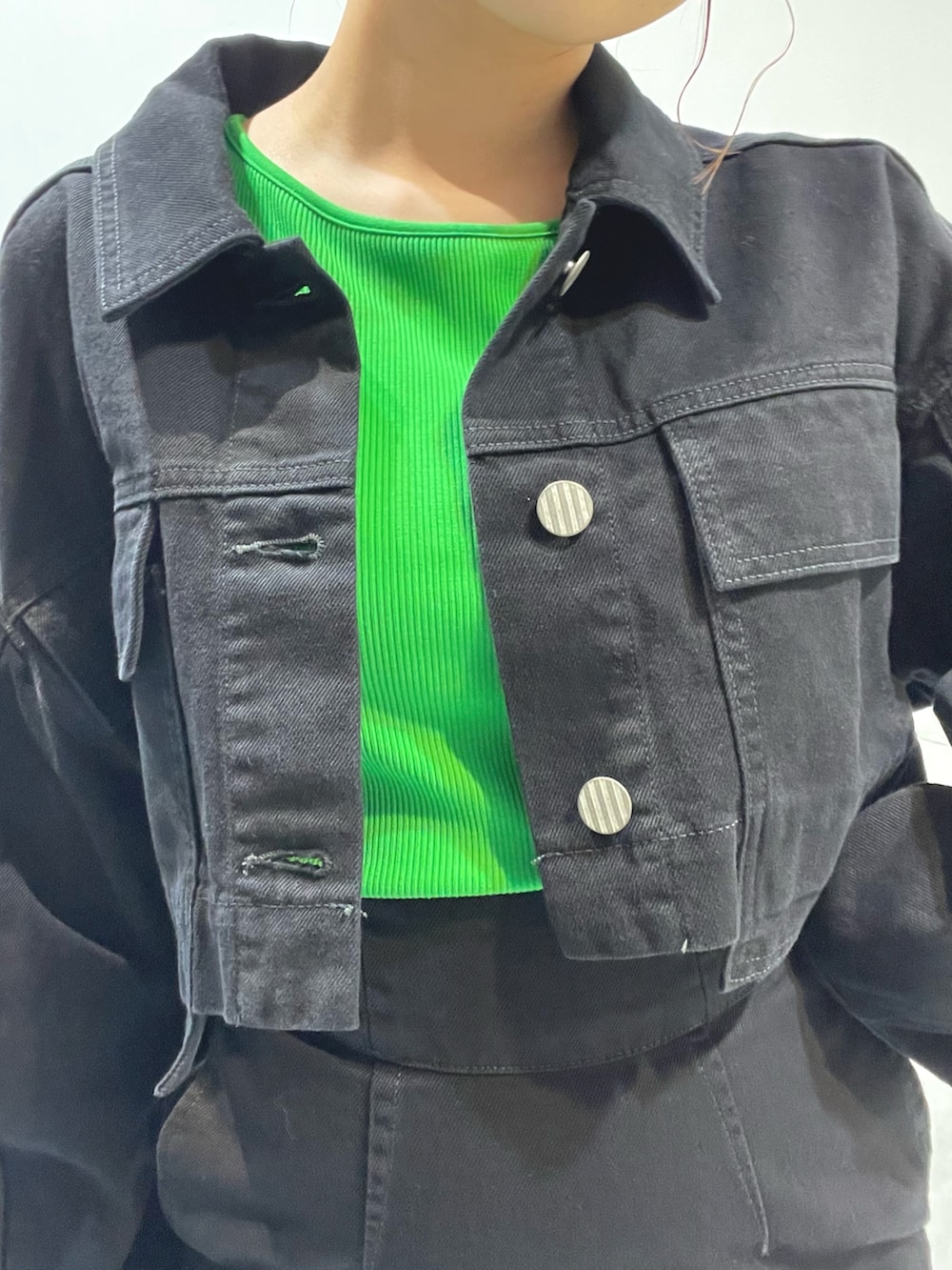 ブラック系のデニムジャケット、ホワイト系のハンドバッグ、ブラック系のサンダルを着用したレディースの夏コーディネートの6枚目の写真