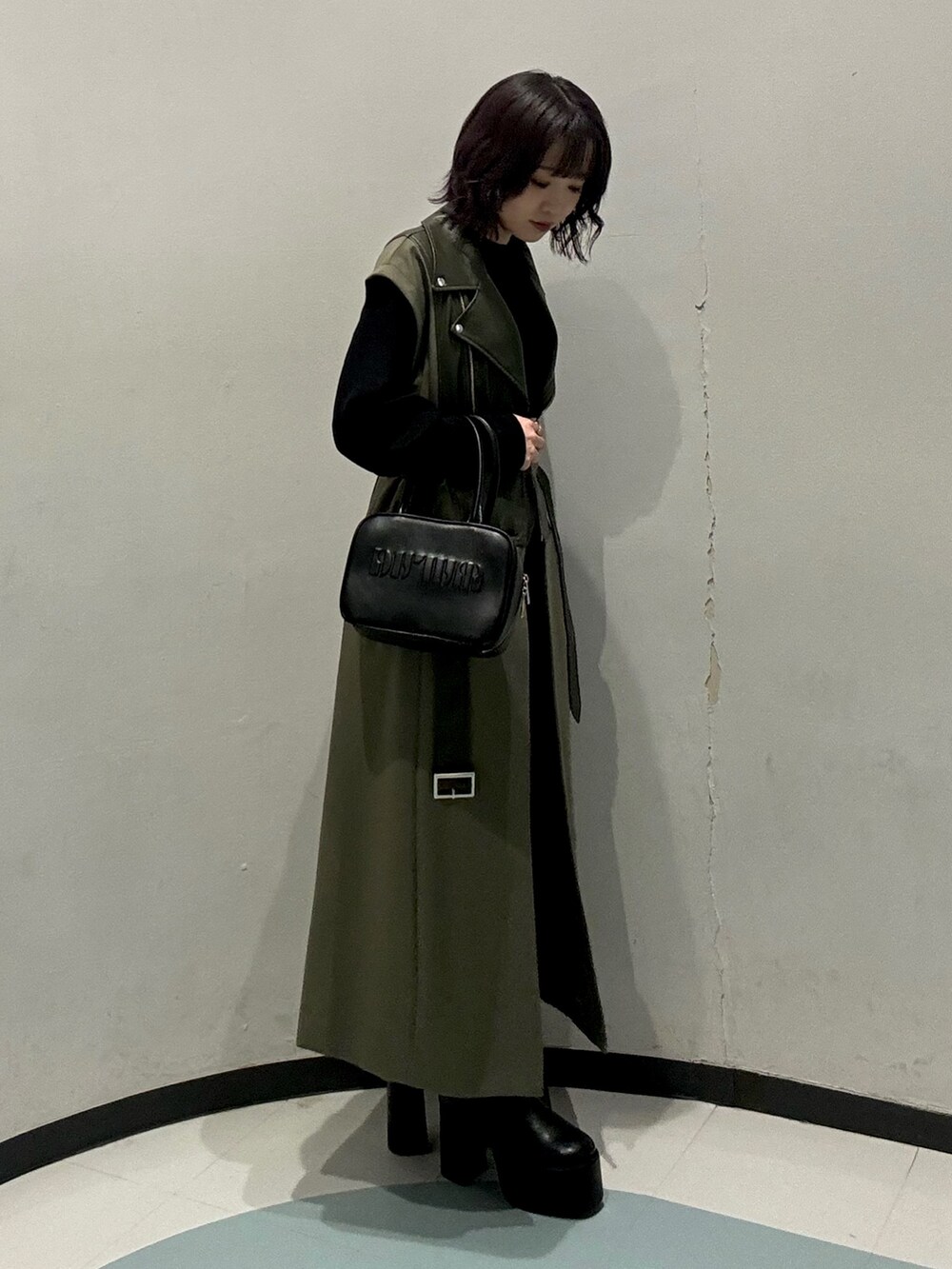 ブラック系のニット/セーター、グリーン系のその他アウター、グレー系のその他パンツを着用したレディースの秋コーディネートの2枚目の写真