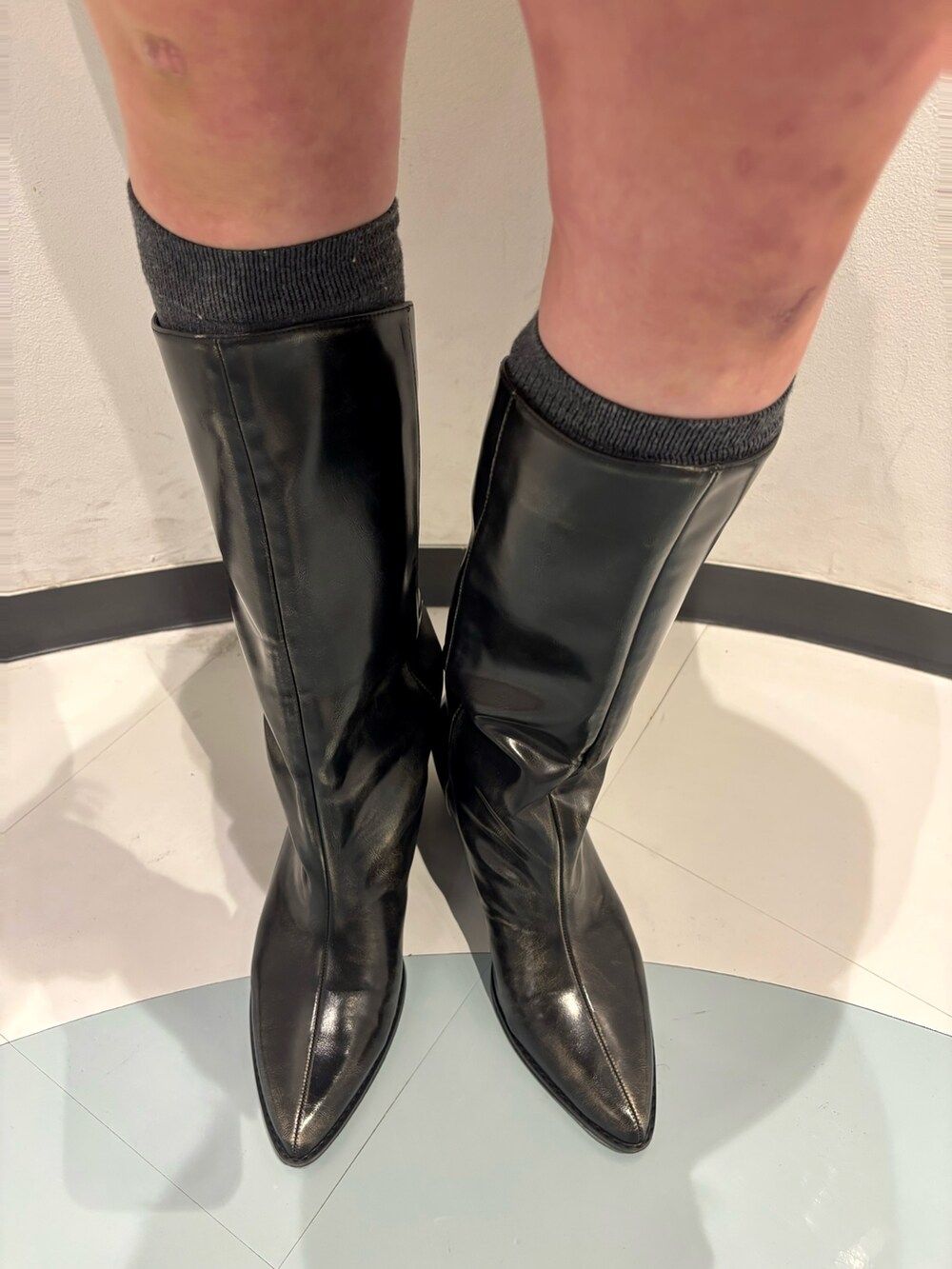 ブラック系のショルダーバッグ、ブラック系のブーツ、ブルー系のワンピースを着用したレディースの冬コーディネートの7枚目の写真