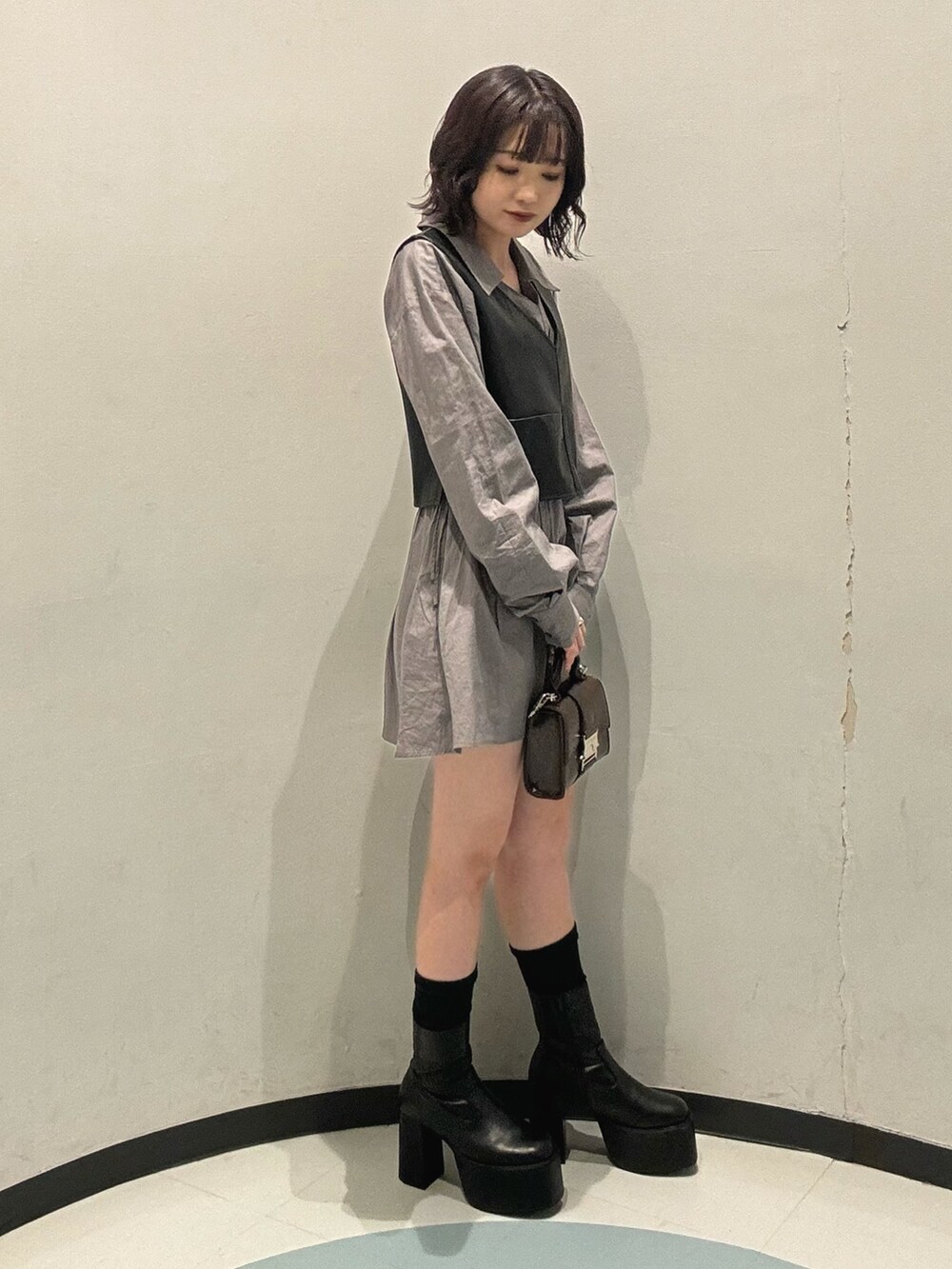 ブラック系のブーツ、グレー系のワンピースを着用したレディースの秋コーディネートの2枚目の写真