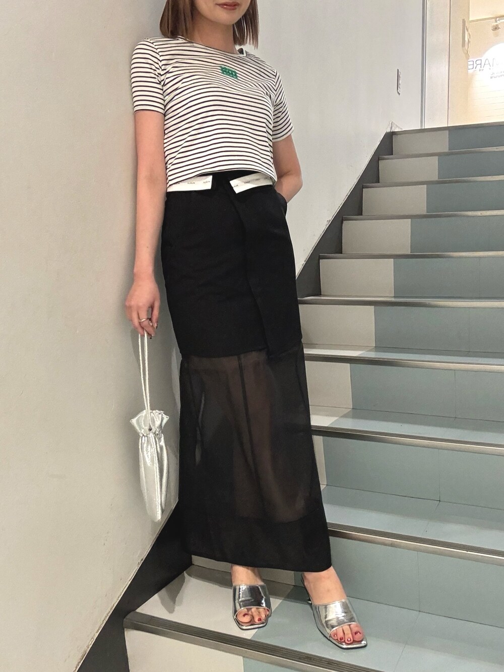 その他のTシャツ/カットソー、ブラック系のスカート、シルバー系のサンダルを着用したレディースの夏コーディネートの5枚目の写真