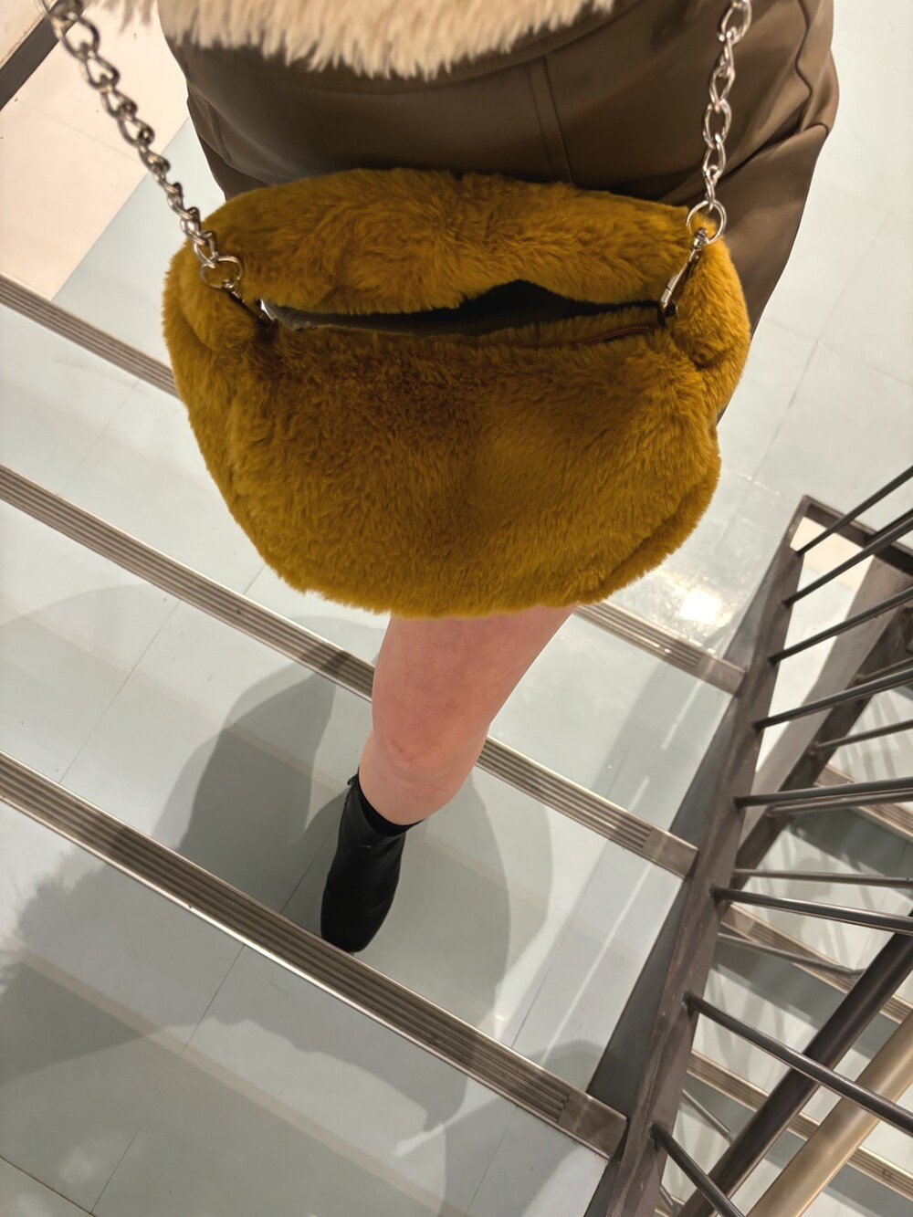 ブラック系のブーツ、ブラウン系のスカート、ブラック系のニット/セーターを着用したレディースの冬コーディネートの5枚目の写真