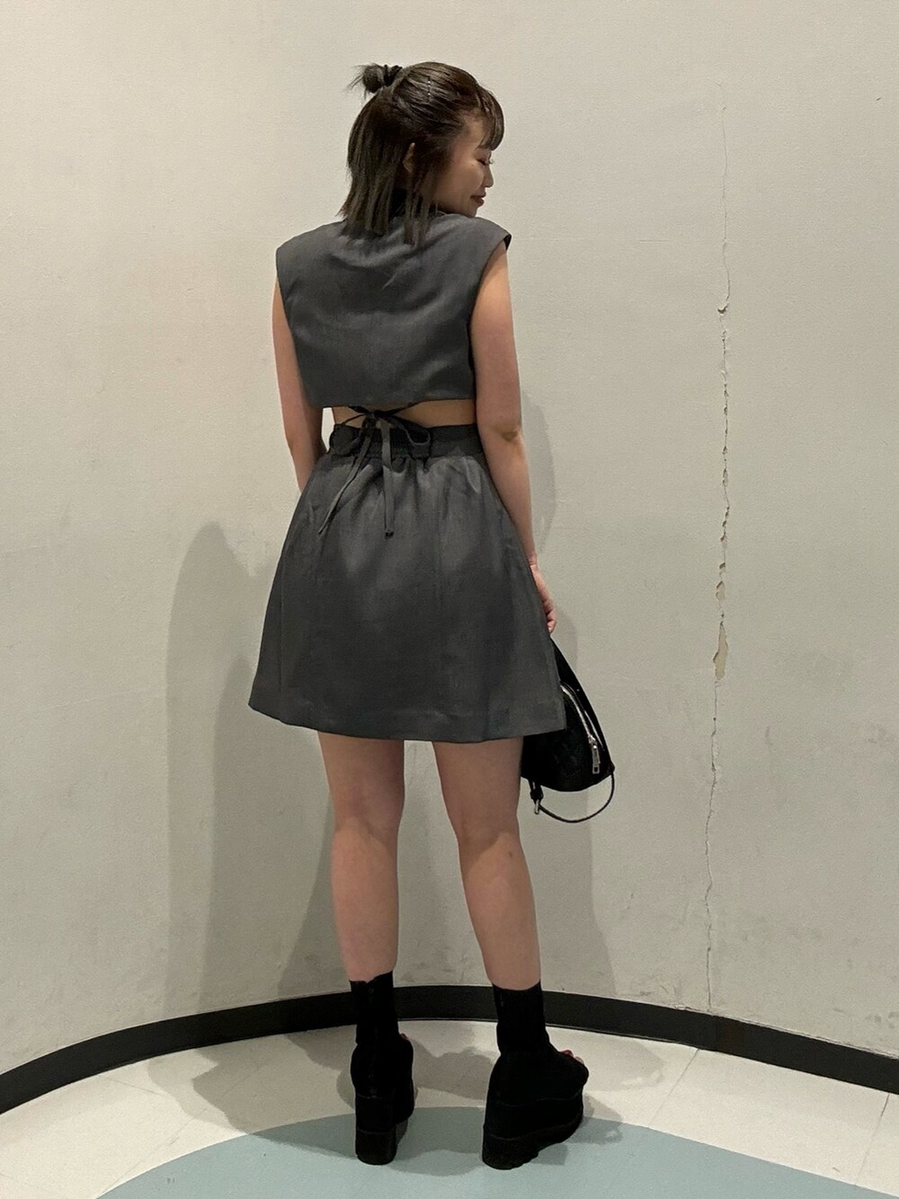 ブラック系のハンドバッグ、グレー系のワンピースを着用したレディースの春コーディネートの3枚目の写真