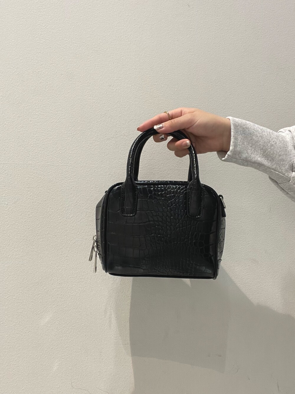 ブラック系のボストンバッグ、グレー系のダウンジャケット/コート、グレー系のワンピースを着用したレディースの夏コーディネートの7枚目の写真