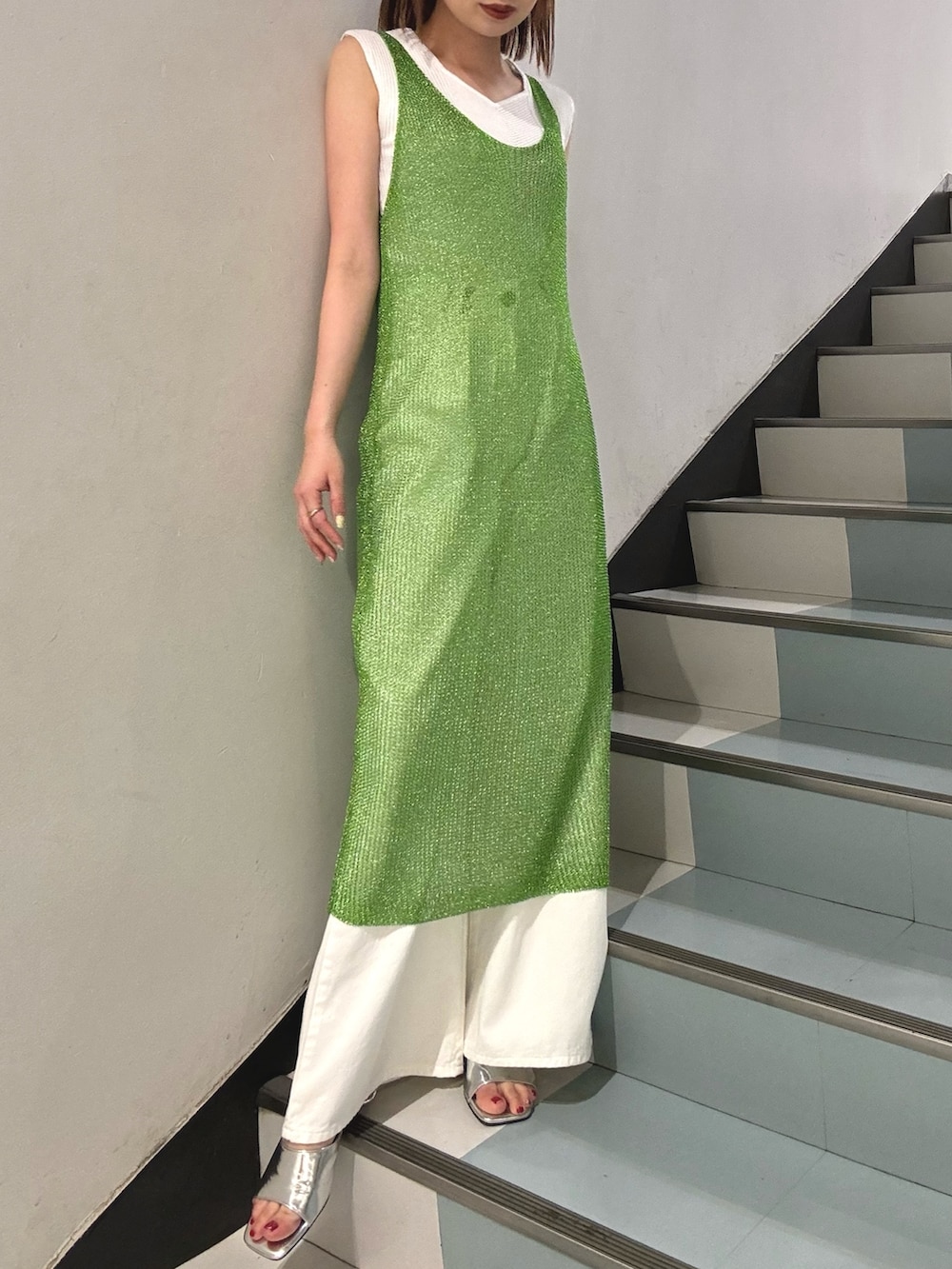 ブラック系のショルダーバッグ、グリーン系のワンピース、シルバー系のサンダルを着用したレディースの夏コーディネートの5枚目の写真