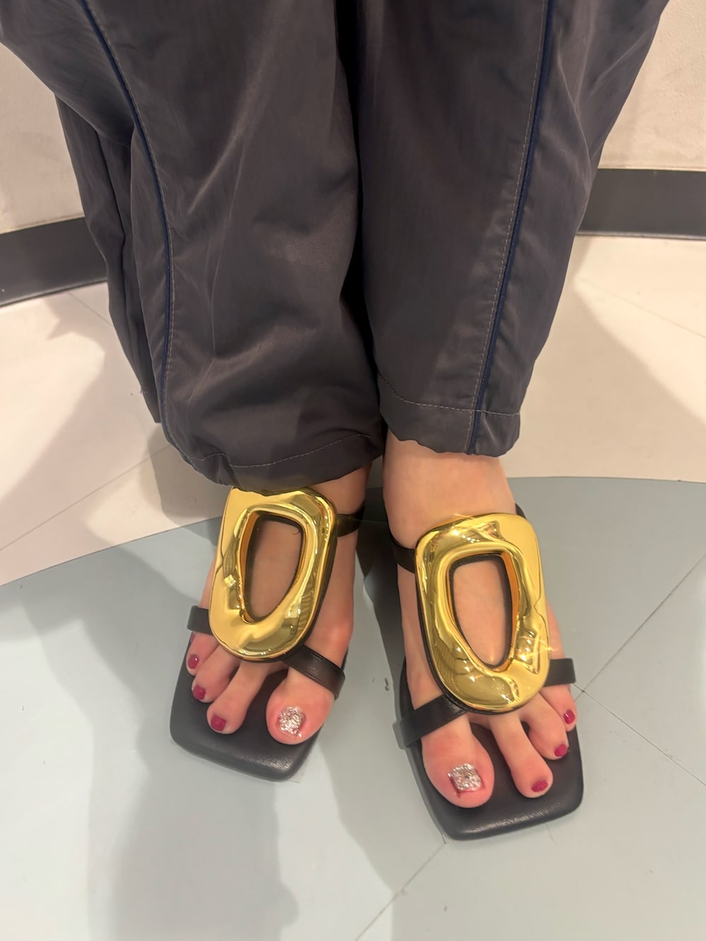 ホワイト系のタンクトップ、グレー系のカーゴパンツ、ブラック系のサンダルを着用したレディースの夏コーディネートの7枚目の写真