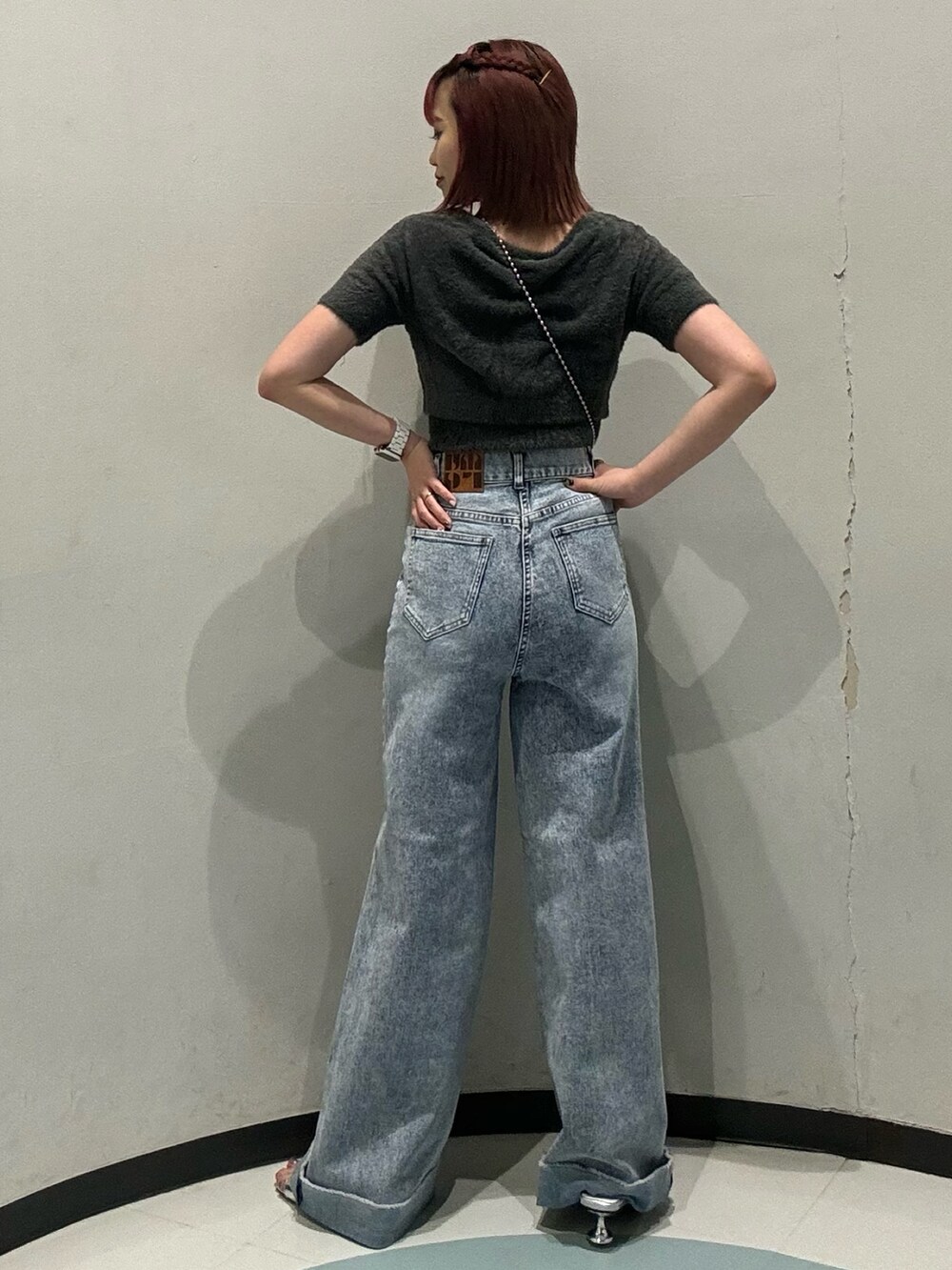 グレー系のニット/セーター、ブルー系のデニムパンツを着用したレディースの夏コーディネートの3枚目の写真