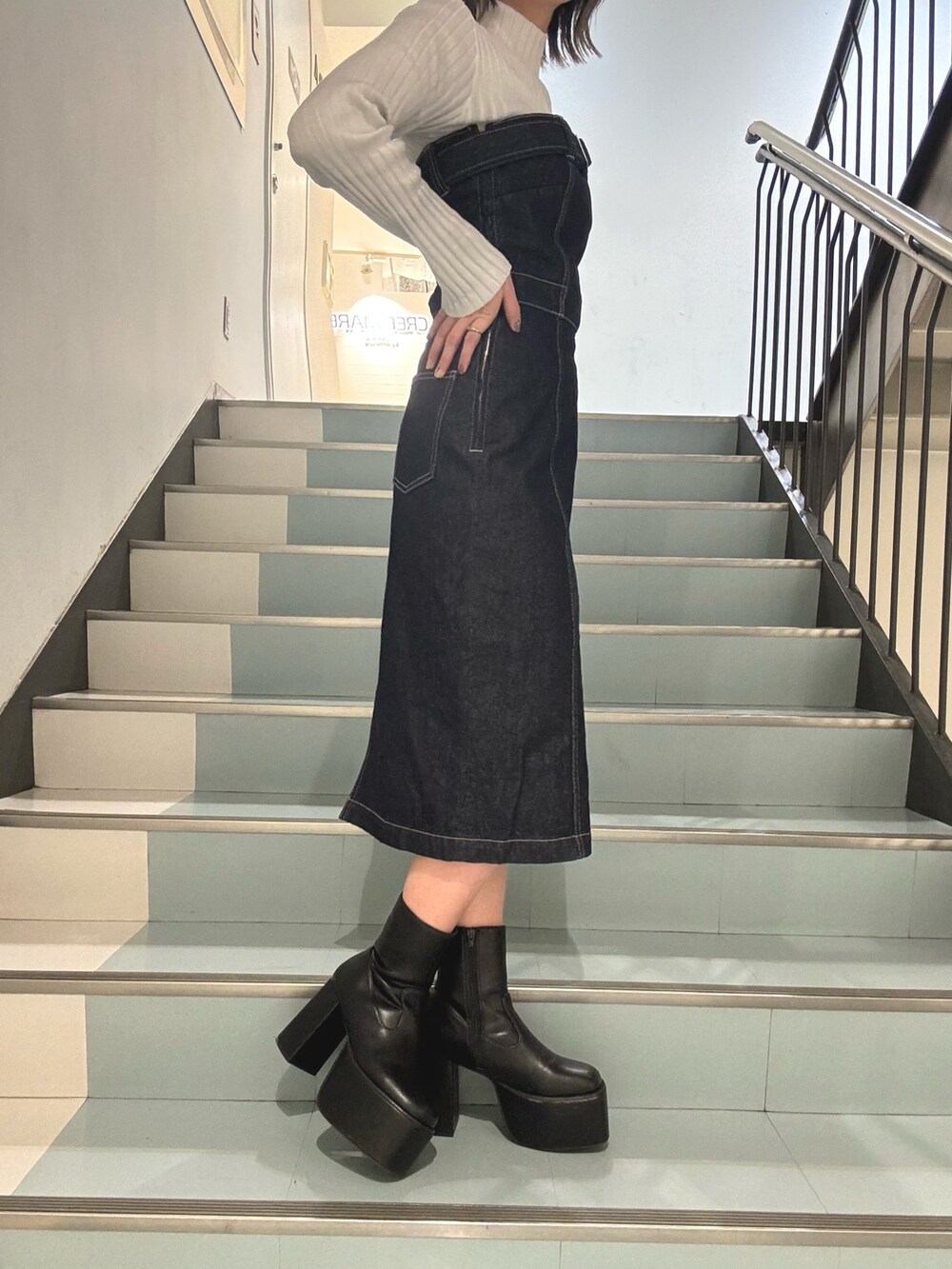 ブラック系のハンドバッグ、ブルー系のデニムジャケット、ブルー系のワンピースを着用したレディースの冬コーディネートの7枚目の写真